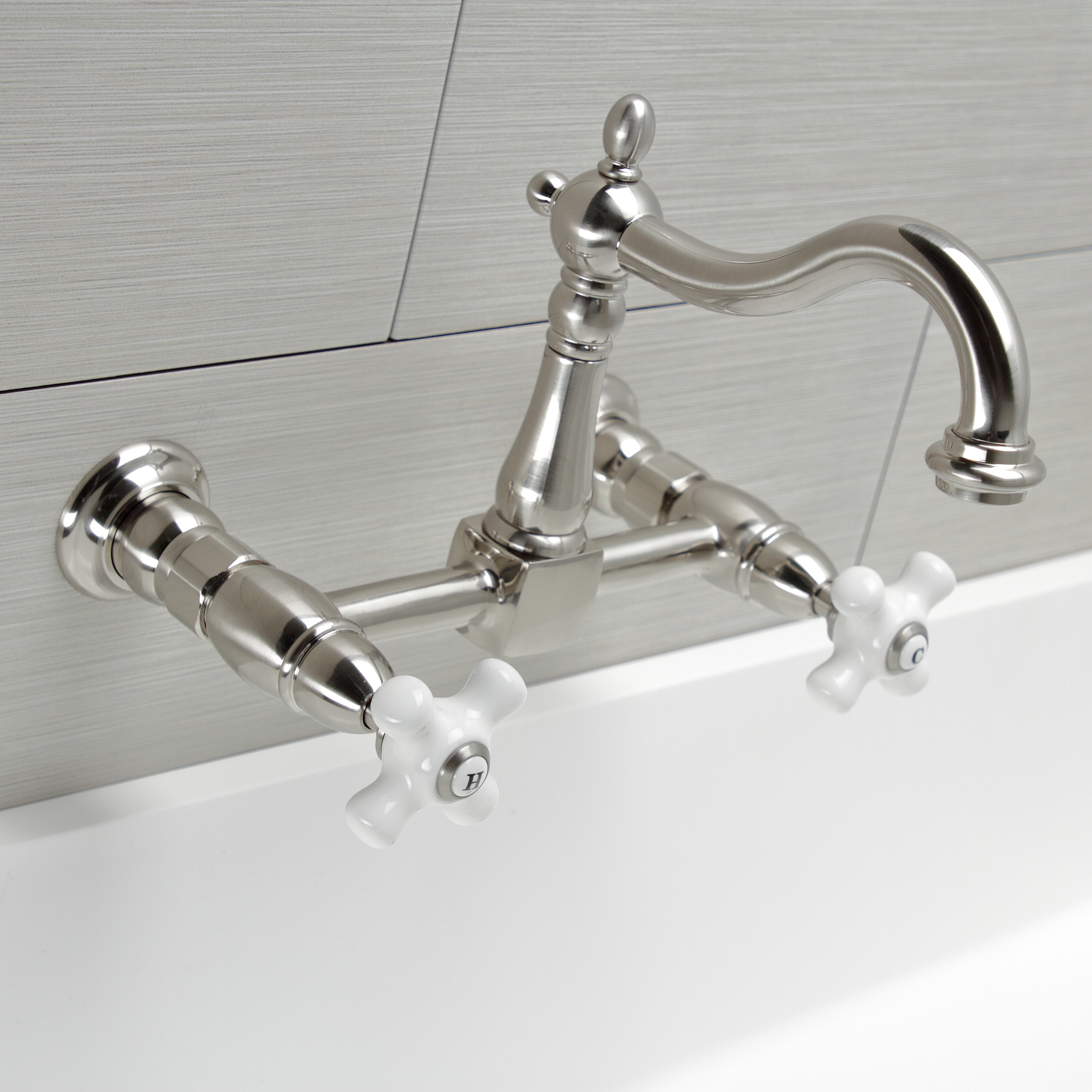 Kingston KS1263PX Heritage Two-Handle Wall Mount Bridge Kitchen Faucet, Antique Brass with white handles and brushed finish