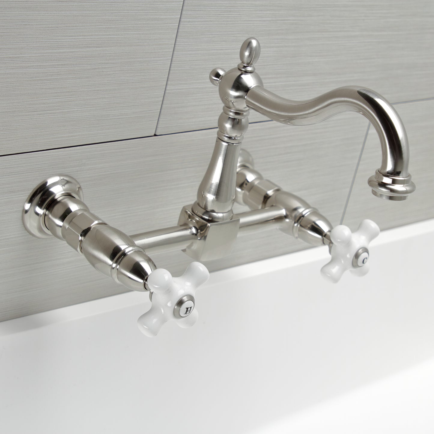 Kingston KS1263PX Heritage Two-Handle Wall Mount Bridge Kitchen Faucet, Antique Brass with white handles and brushed finish