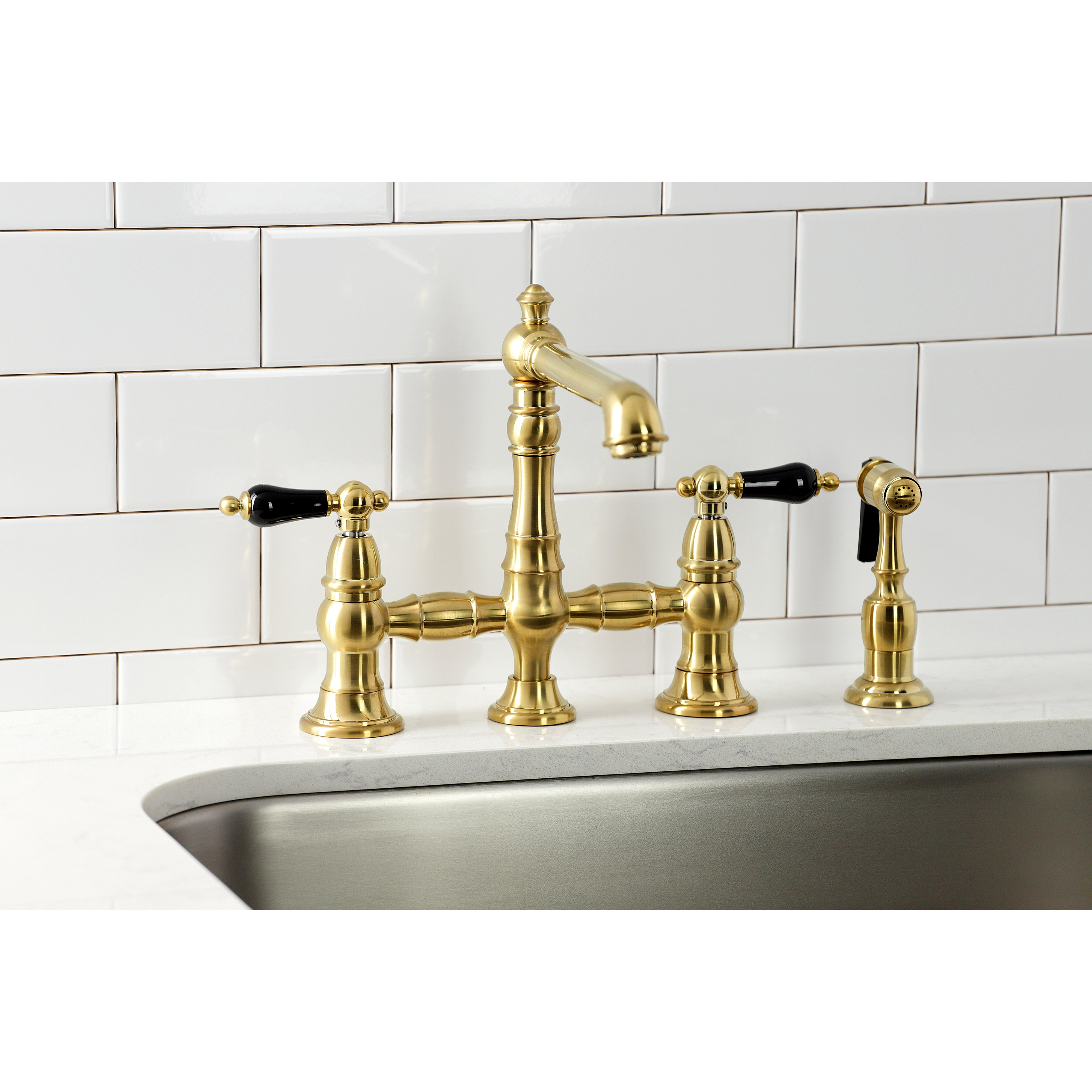 Kingston KS7277PKLBS Duchess Bridge Kitchen Faucet with Brass Sprayer, Brushed Brass on a kitchen counter