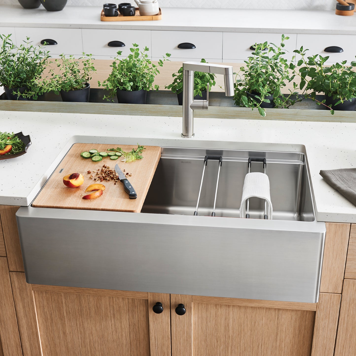BLANCO Quatrus R15 Ergon 33" Single Bowl Apron-Front Stainless Steel Farmhouse Sink with cutting board and fresh ingredients.