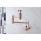 Kingston Brass KS8103ZX Millennium Wall Mount Pot Filler Faucet, Antique Brass mounted above a marble surface.