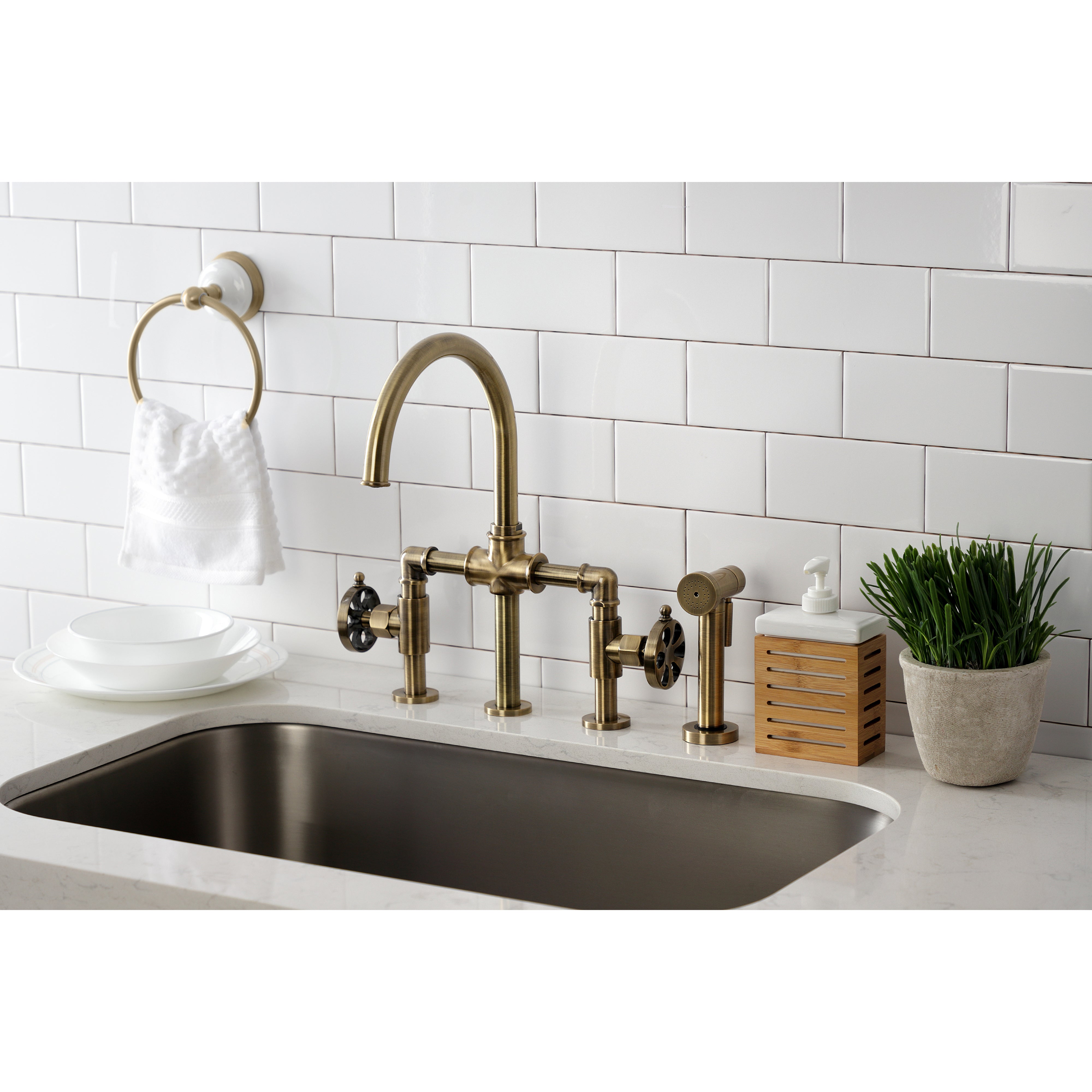 Kingston KS2333RX Belknap Industrial Style Bridge Kitchen Faucet with Brass Sprayer, Antique Brass in a modern kitchen setting.