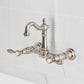 Kingston KS2443TAL Tudor Two-Handle Wall Mount Bridge Kitchen Faucet, Antique Brass on a modern backsplash.