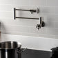 Kingston Brass KS4103RKX Webb Wall Mount Pot Filler Faucet with Knurled Handle, Antique Brass on a modern kitchen wall.