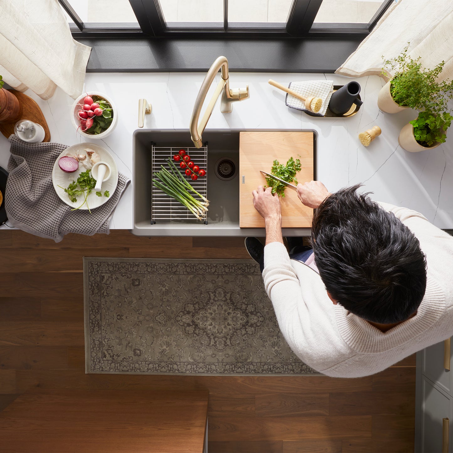 BLANCO Ikon SILGRANIT 30" Single Bowl Apron-Front Farmhouse Sink with chef chopping vegetables in a stylish kitchen.