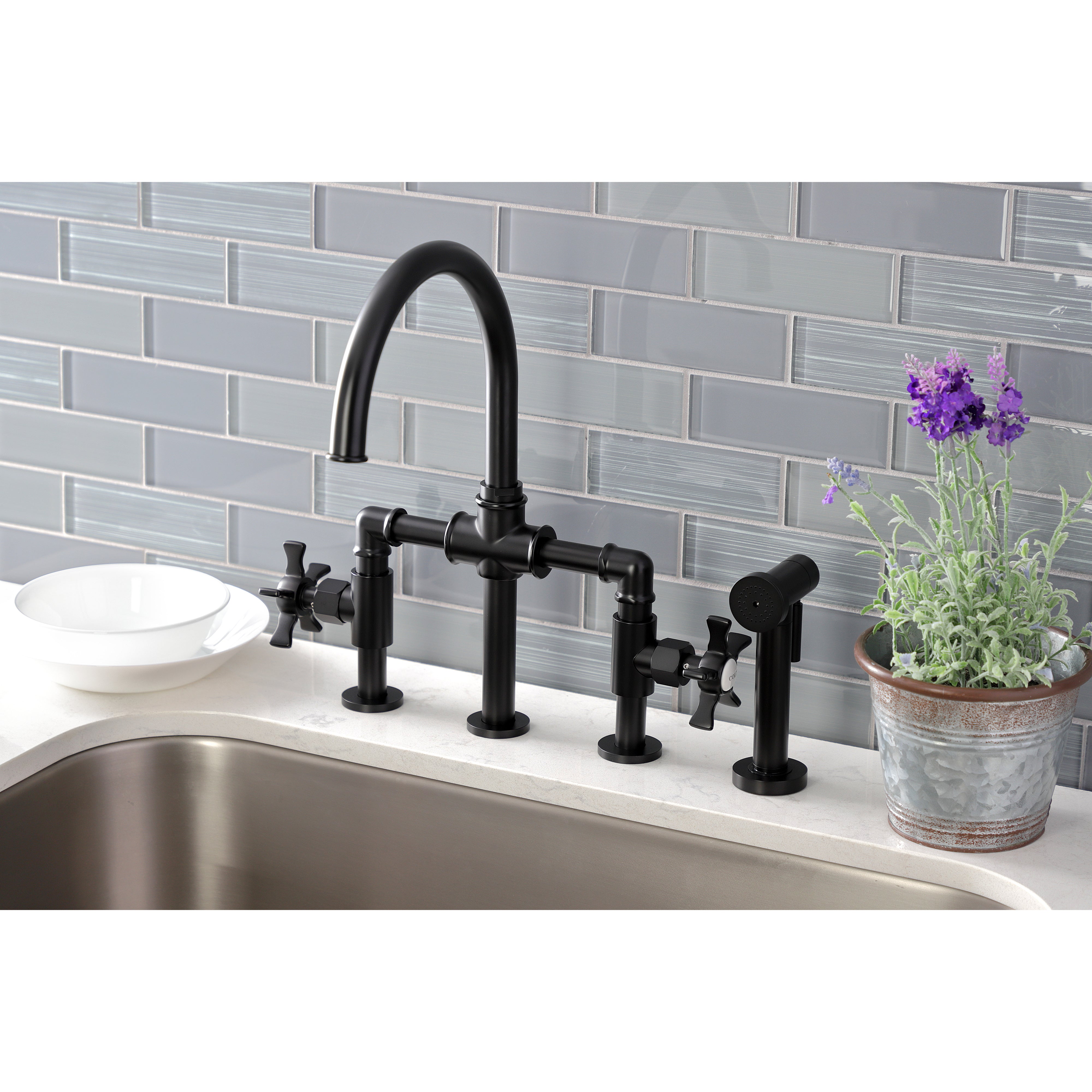 Kingston KS2333NX Hamilton Industrial Style Bridge Kitchen Faucet with Brass Sprayer, Antique Brass in a modern kitchen setting.