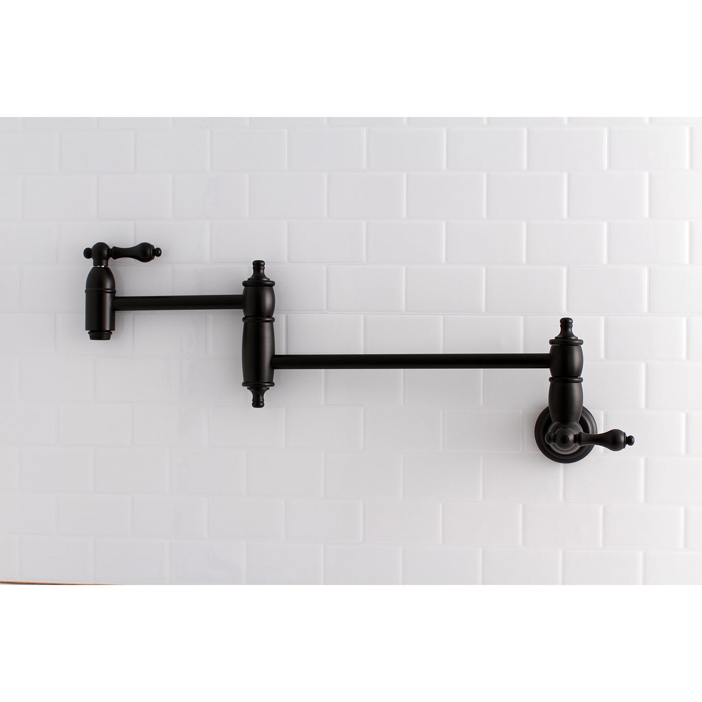 Kingston Brass KS3103AL Restoration Wall Mount Pot Filler Faucet, Antique Brass mounted on white tile background.