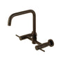Kingston Brass KS8168DL Concord Wall Mount Bridge Kitchen Faucet in bronze finish with gooseneck design and dual handles.