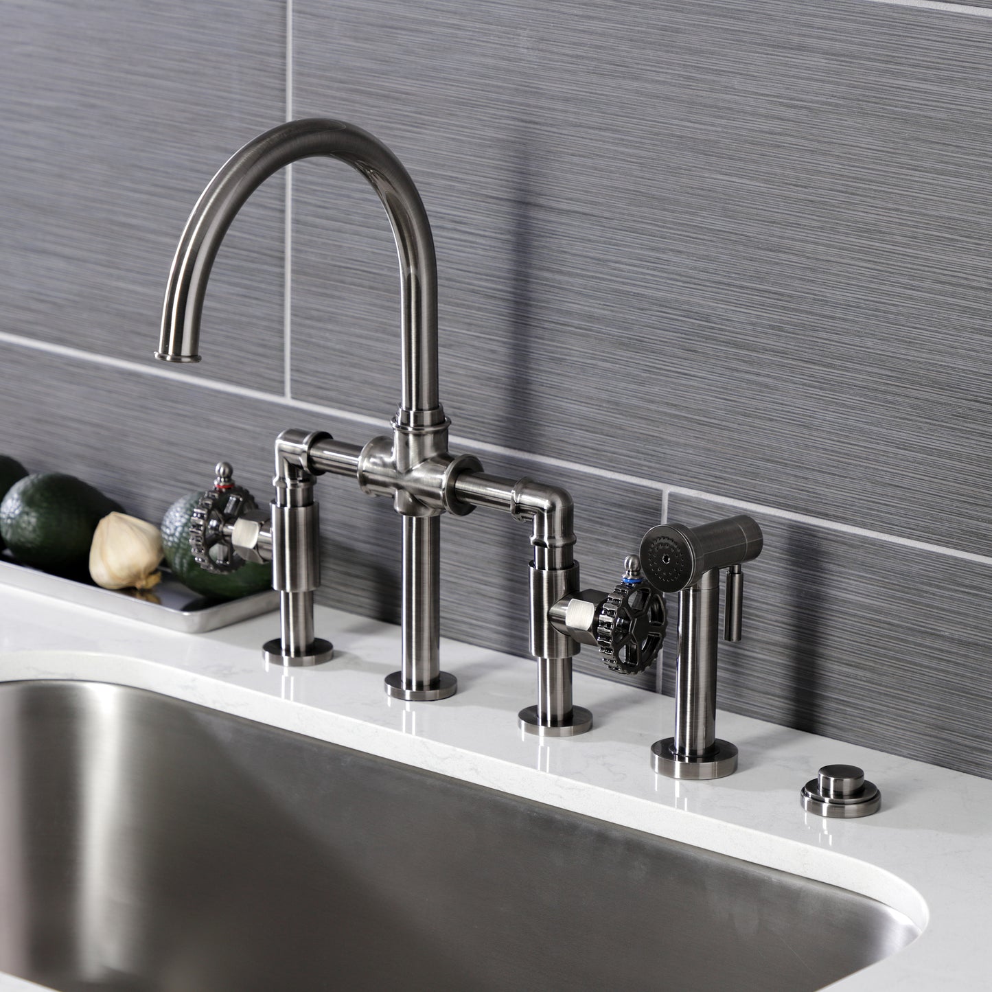 Kingston KS2334CG Fuller Industrial Style Bridge Kitchen Faucet with Brass Sprayer, Black Stainless installed in a modern kitchen.