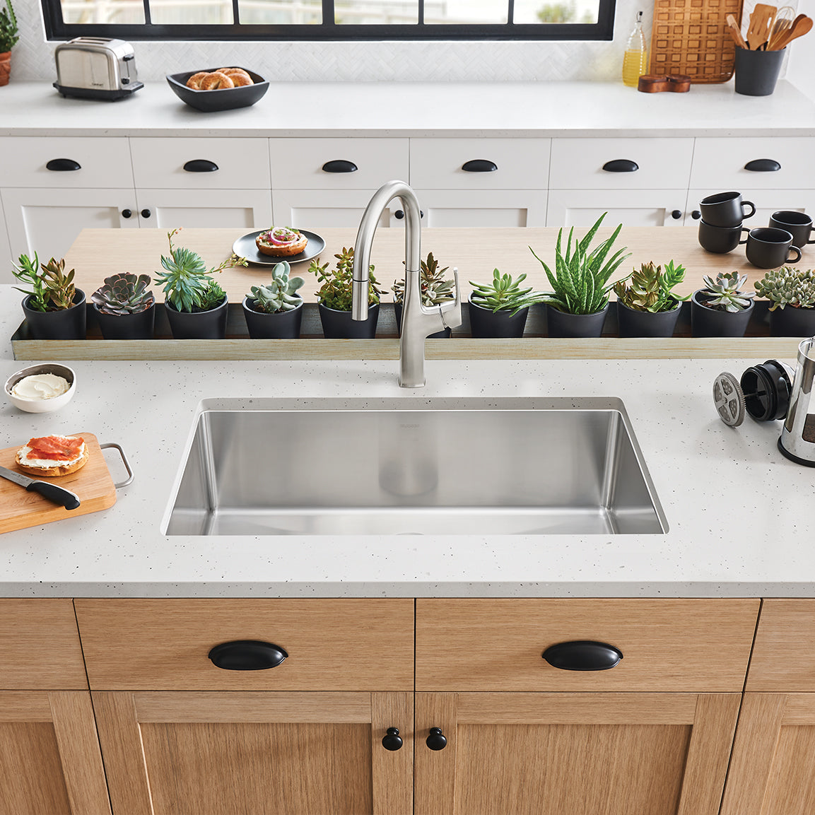 BLANCO Cuvee R15 32" Single Bowl Undermount Stainless Steel Kitchen Sink in a modern kitchen setting with plants and decor.