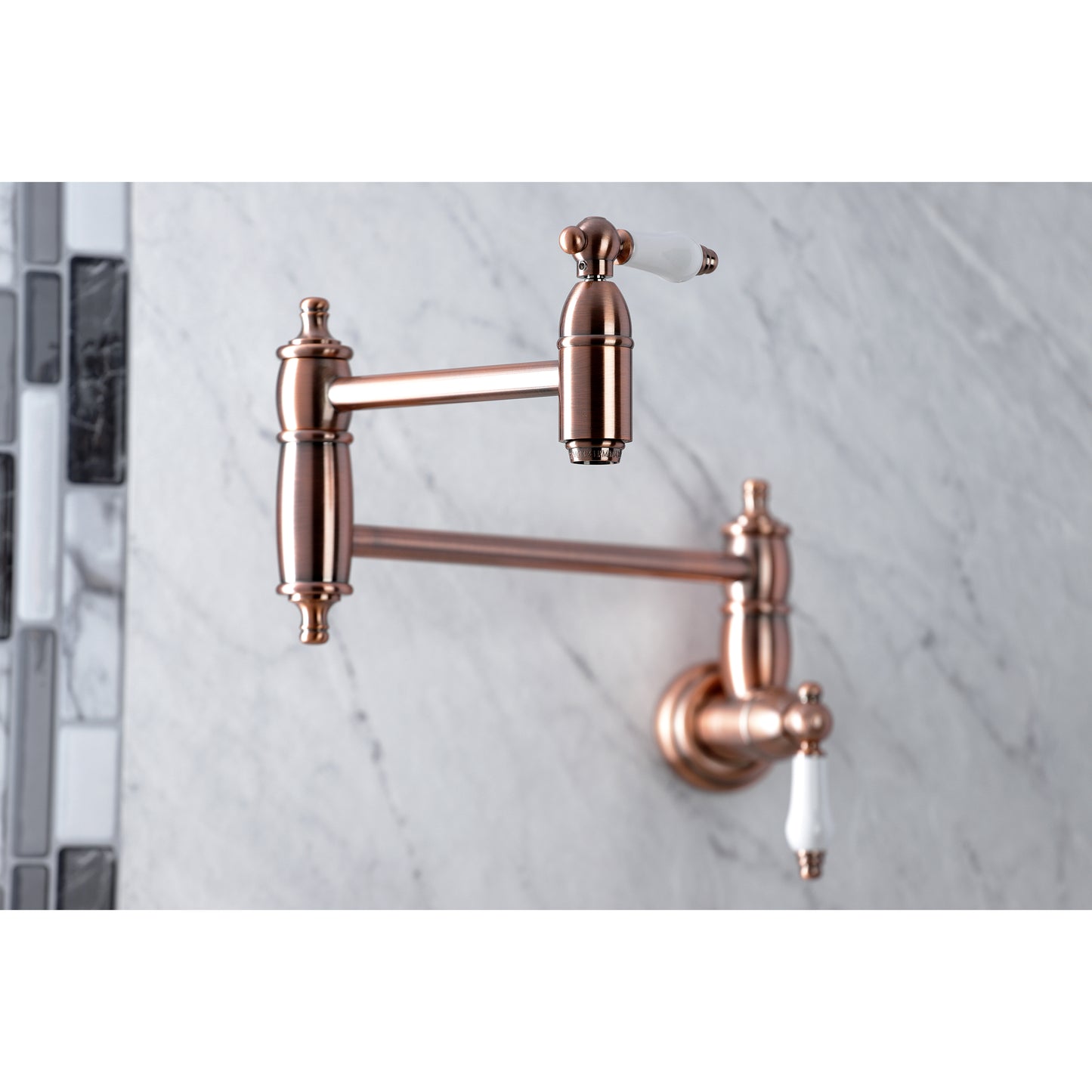 Kingston Brass KS3103PL Restoration Wall Mount Pot Filler Faucet, Antique Brass close-up on marble wall