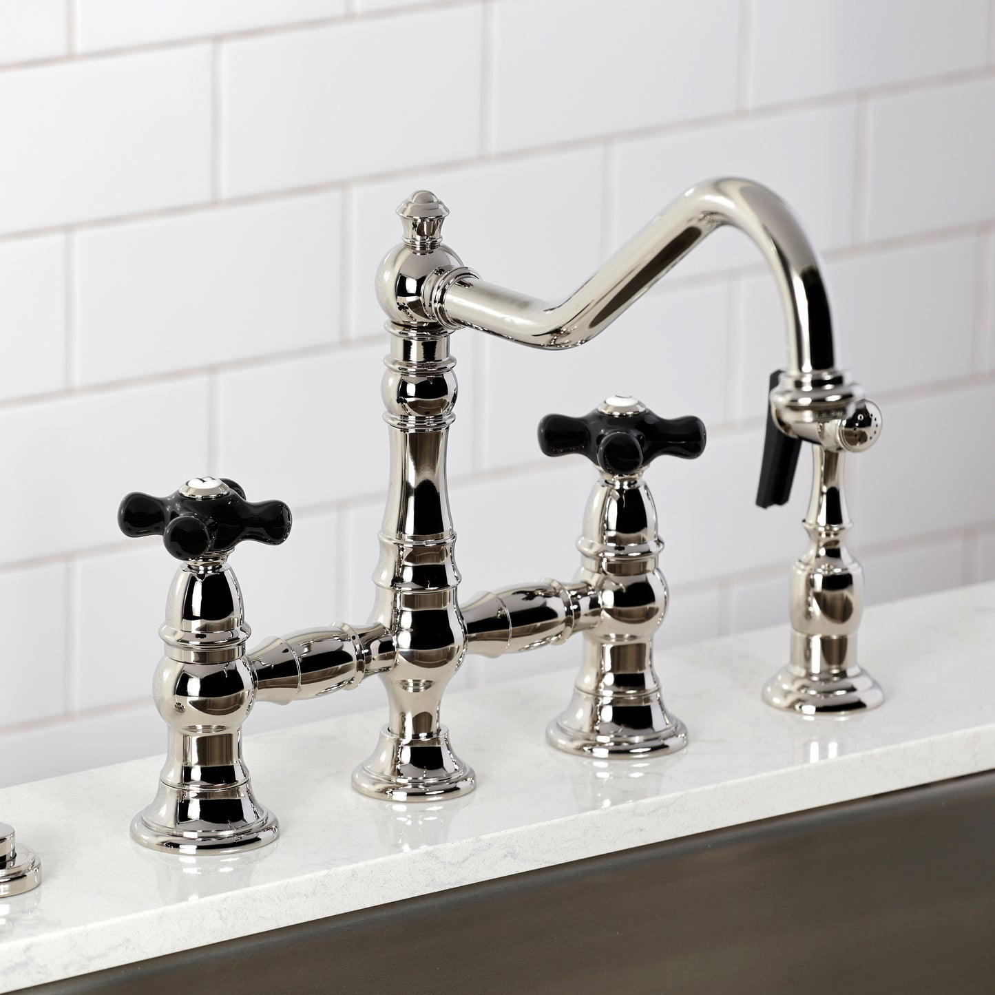 Kingston KS3277PKXBS Duchess Bridge Kitchen Faucet with Brass Sprayer, Brushed Brass on a kitchen countertop.
