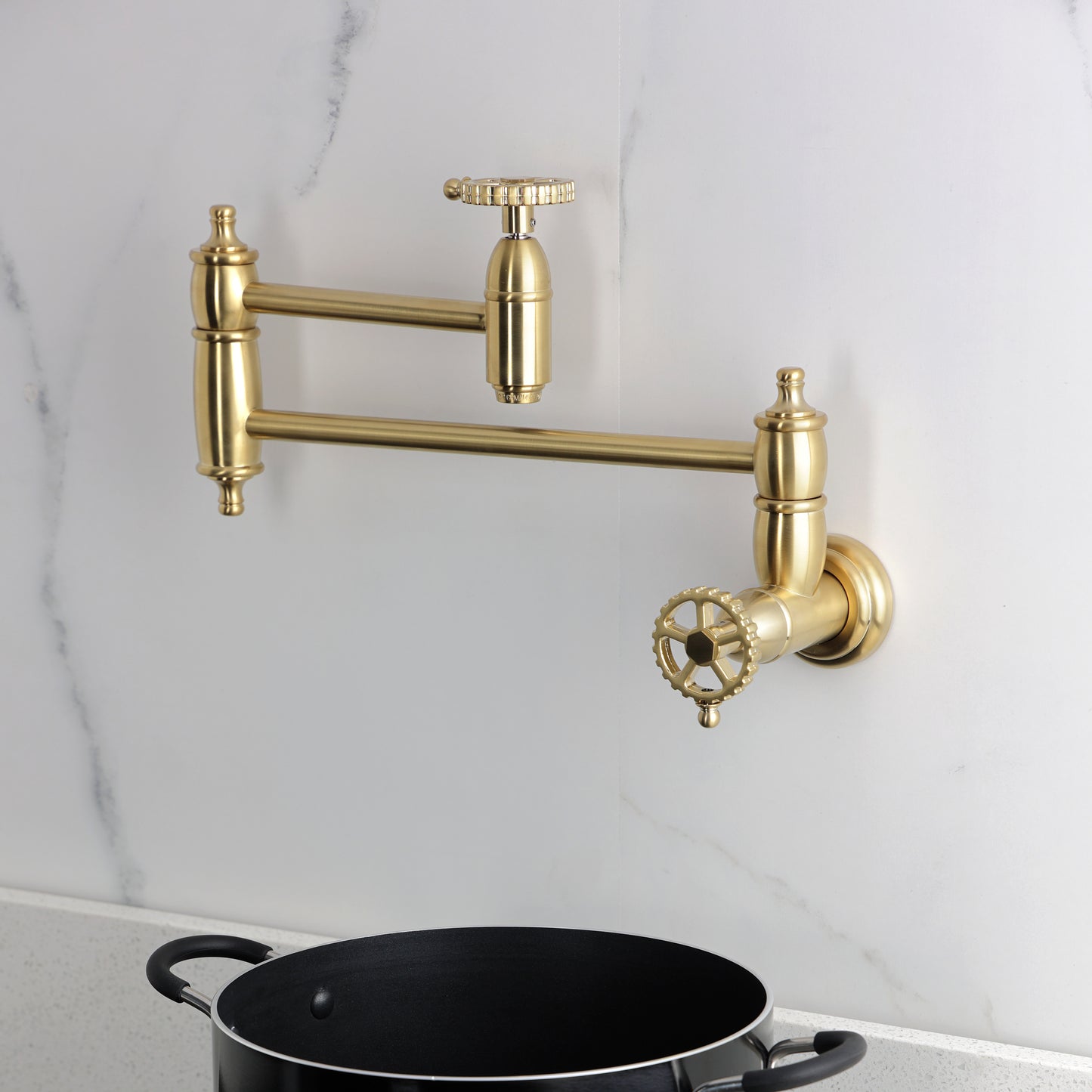 Kingston Brass KS3103CG Fuller Wall Mount Pot Filler Faucet, Antique Brass mounted above black pot.