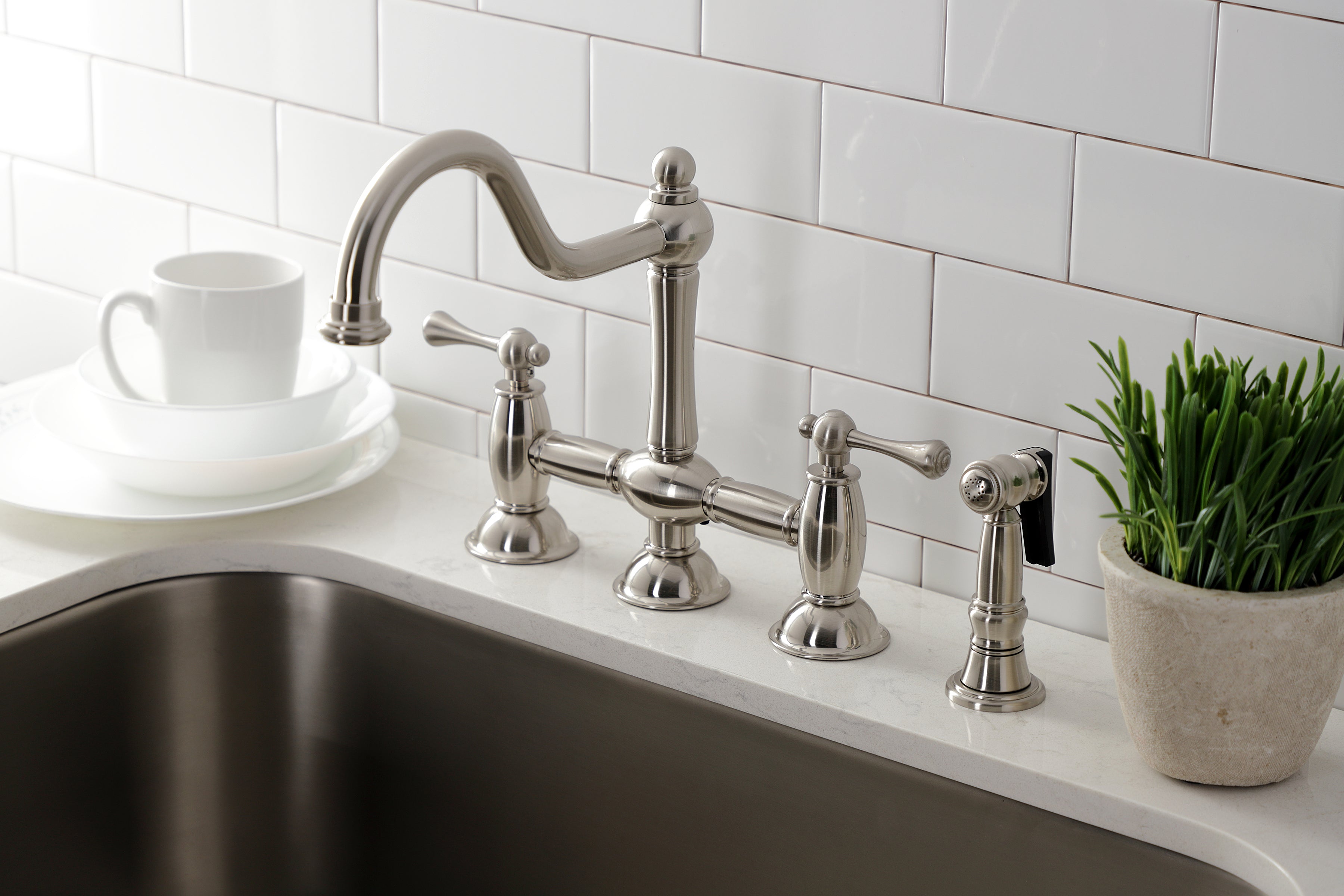 Kingston KS3798BLBS Restoration Bridge Kitchen Faucet with Brass Sprayer, Brushed Nickel showcased in a modern kitchen setting.