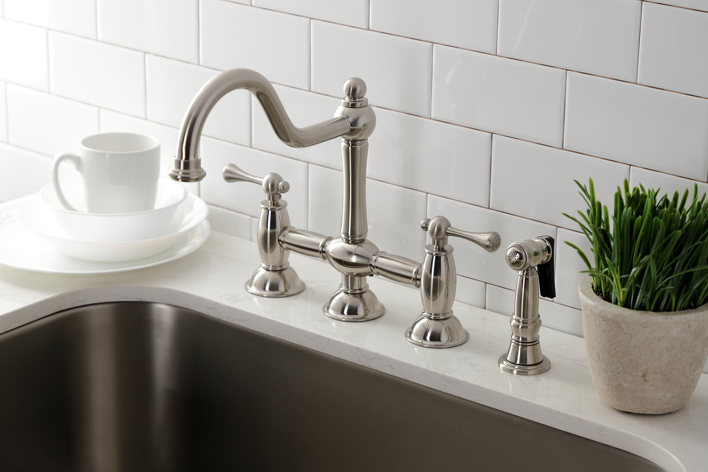 Kingston KS3798BLBS Restoration Bridge Kitchen Faucet with Brass Sprayer, Brushed Nickel showcased in a modern kitchen setting.