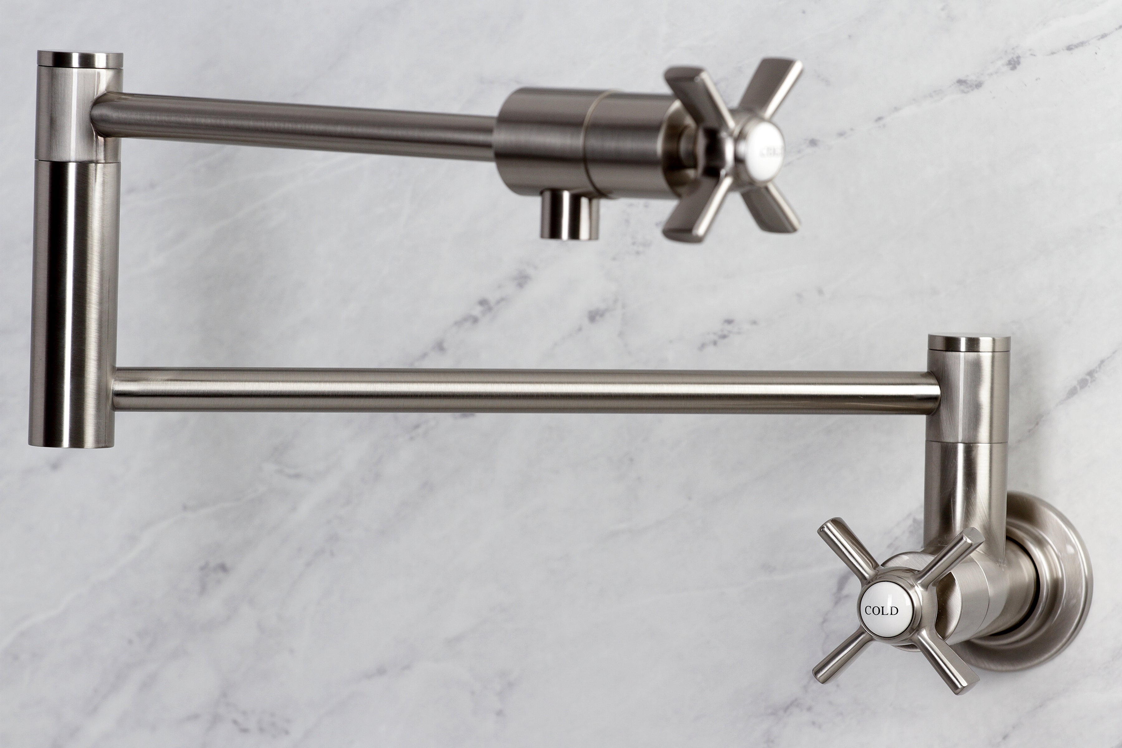 Kingston Brass KS4107ZX Millennium Wall Mount Pot Filler Faucet, Brushed Brass with cross handles and foldable swing arms.