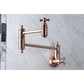 Kingston Brass KS3103AX Restoration Wall Mount Pot Filler Faucet, Antique Brass on marble background.