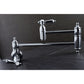 Kingston Brass KS3103BAL Heirloom Wall Mount Pot Filler Faucet, Antique Brass on a dark background.