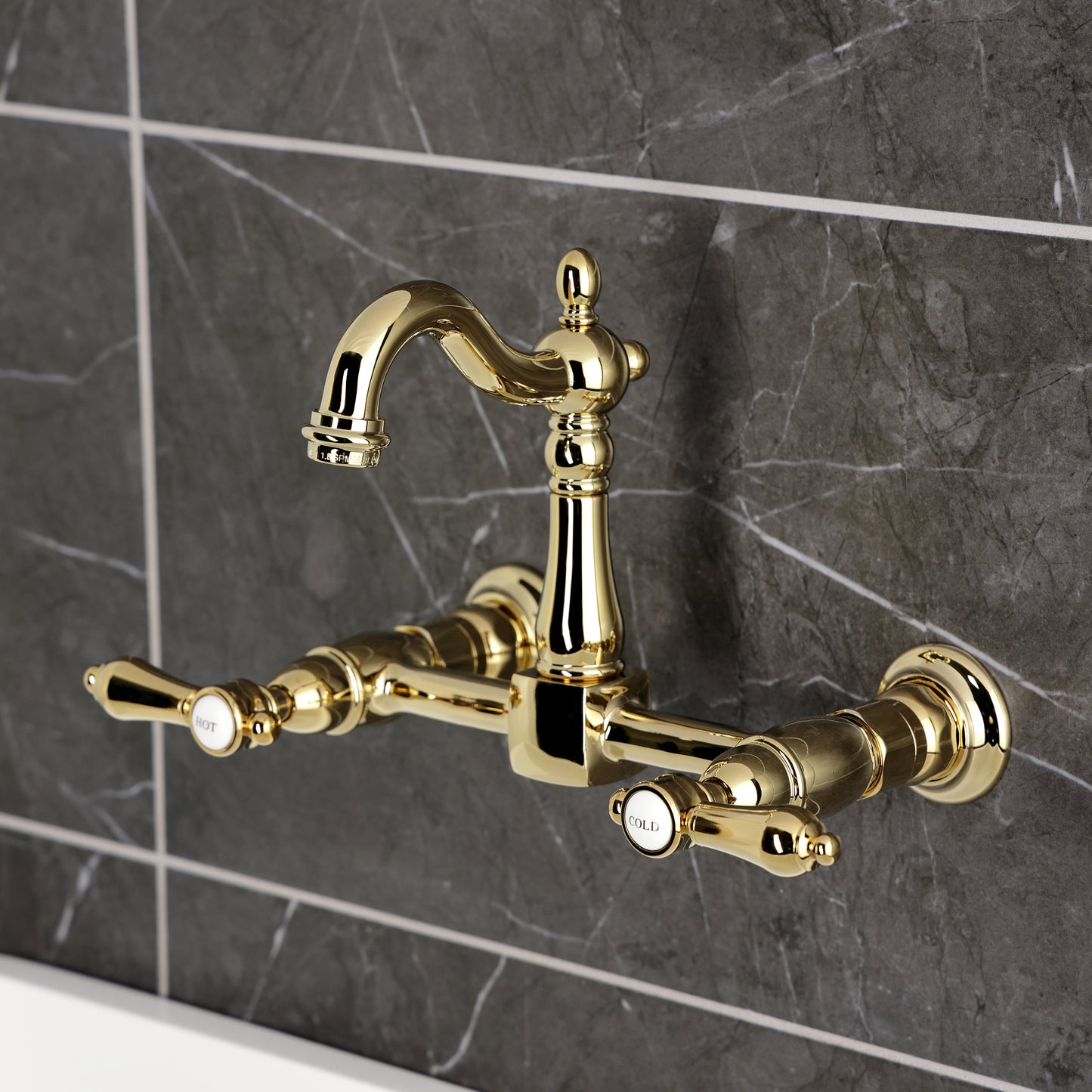Kingston KS2443BAL Heirloom Two-Handle Wall Mount Bridge Kitchen Faucet, Antique Brass on dark tile background.