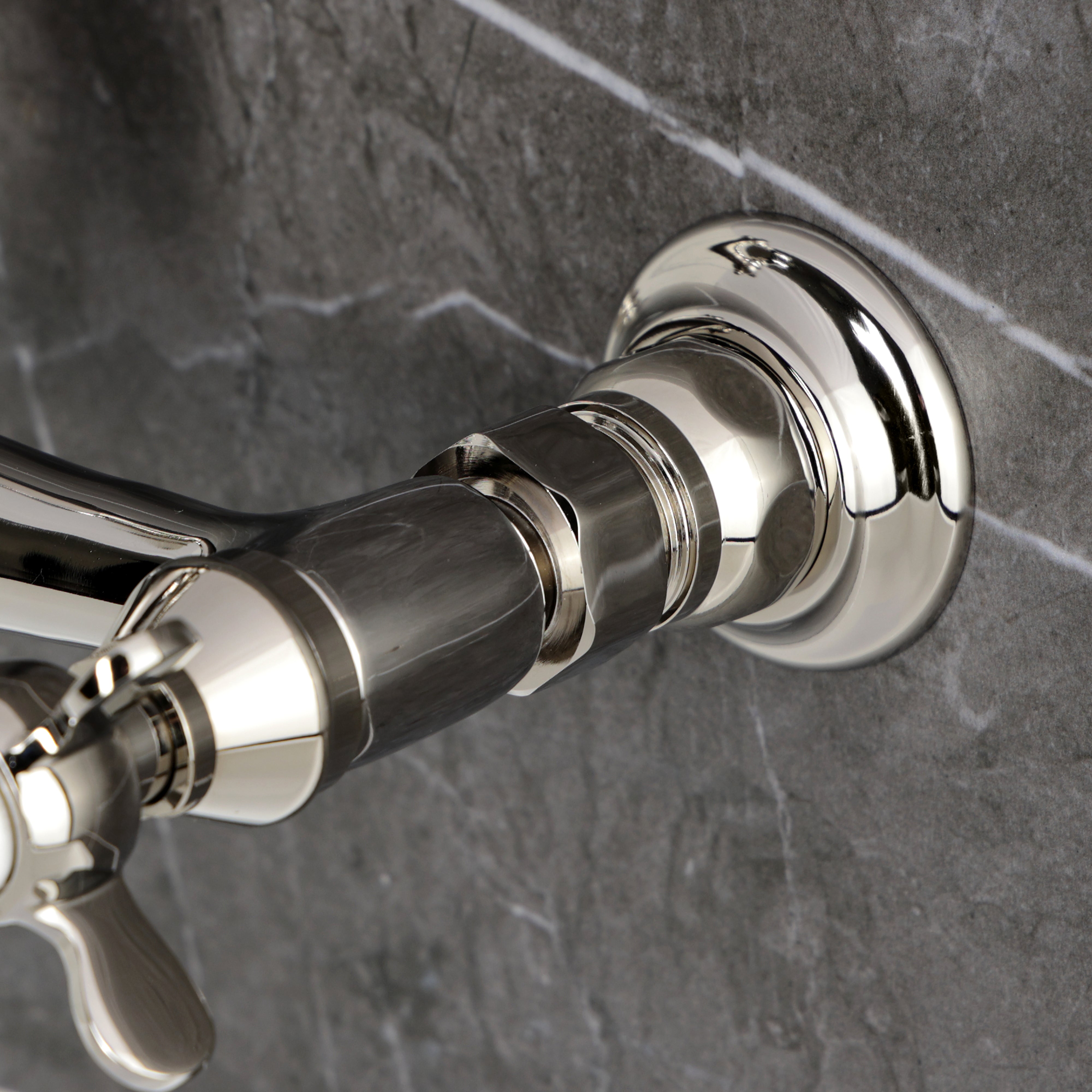 Kingston KS3253BEX Essex Two-Handle Wall Mount Bridge Kitchen Faucet, Antique Brass close-up on faucet handle