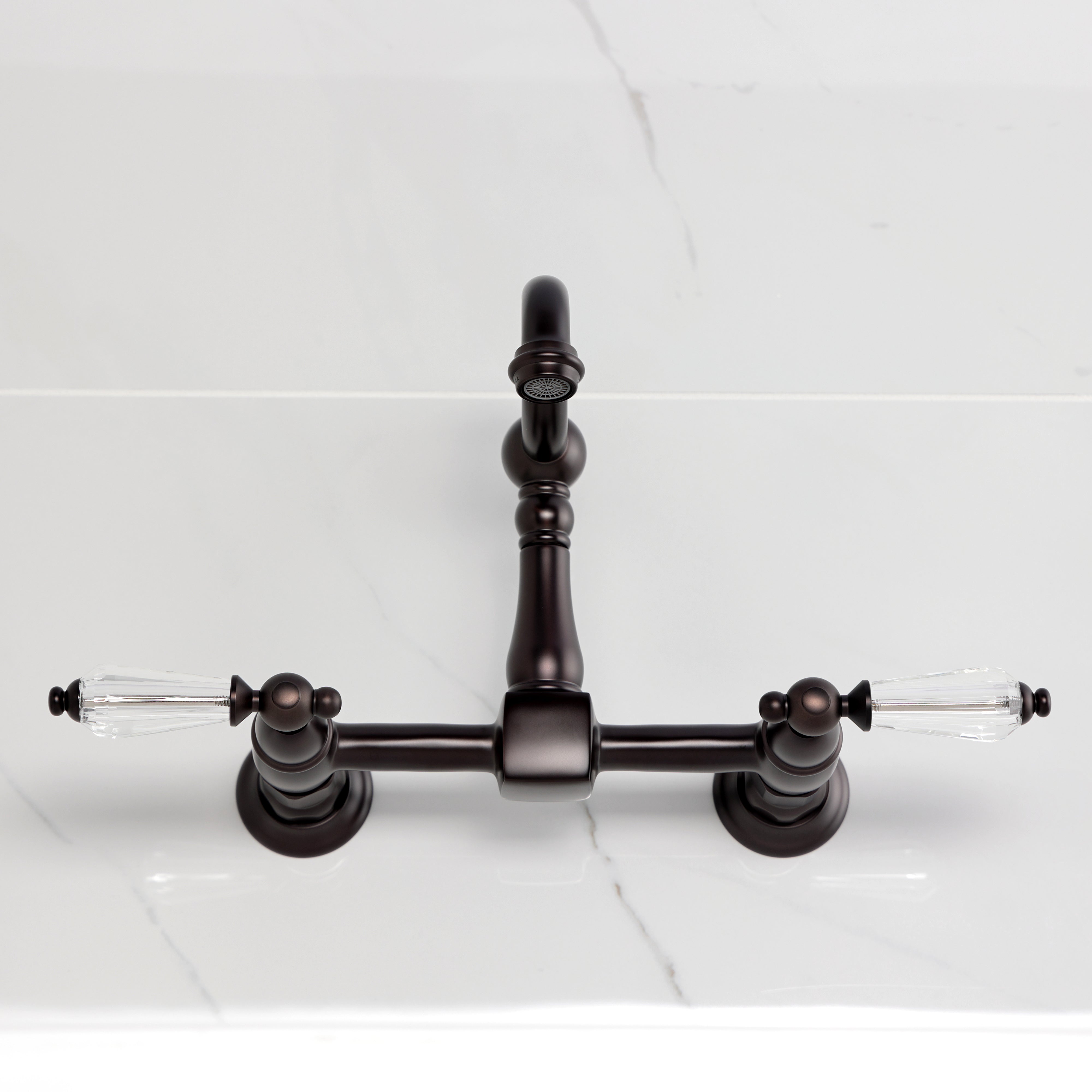 Kingston KS2443WLL Willshire Two-Handle Wall Mount Bridge Kitchen Faucet, Antique Brass top view on marble countertop