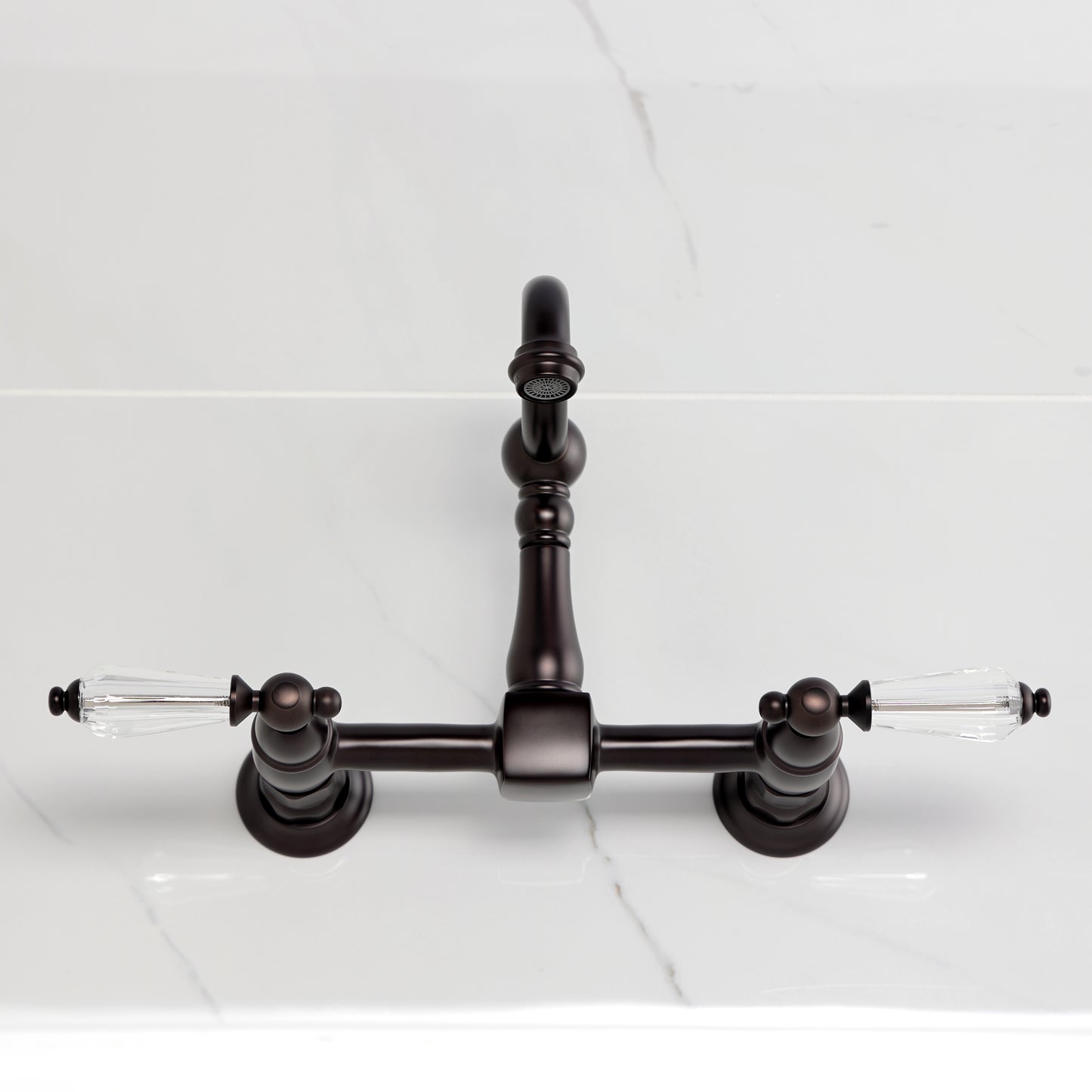 Kingston KS2443WLL Willshire Two-Handle Wall Mount Bridge Kitchen Faucet, Antique Brass top view on marble countertop