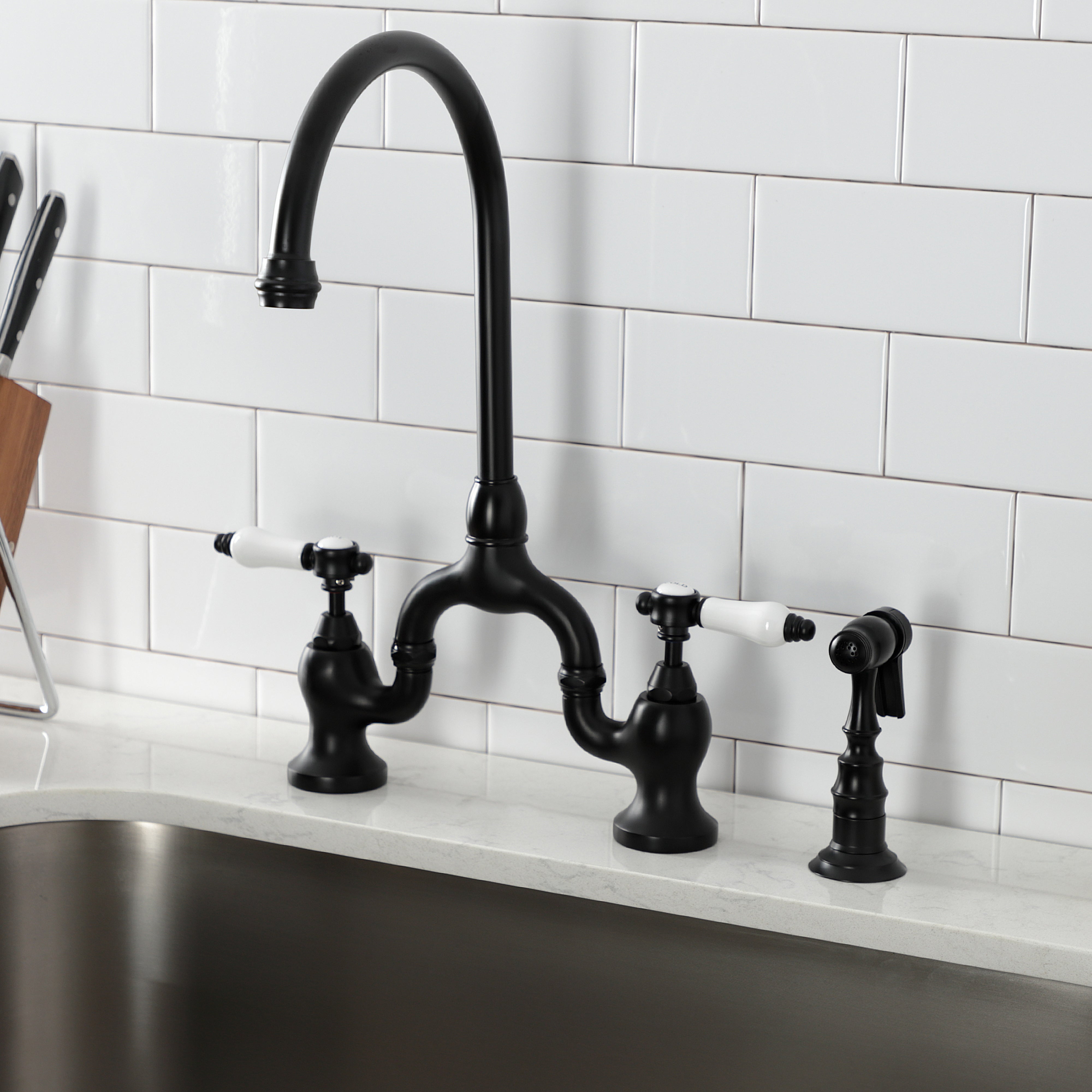Kingston KS7793BPLBS Bel-Air Bridge Kitchen Faucet with Brass Sprayer, Antique Brass in modern kitchen setting.