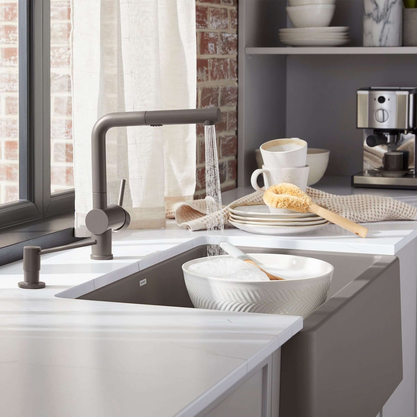 BLANCO Linus Low Arc Pull-Out Dual-Spray Kitchen Faucet - Volcano Gray in a modern kitchen sink with dishes.