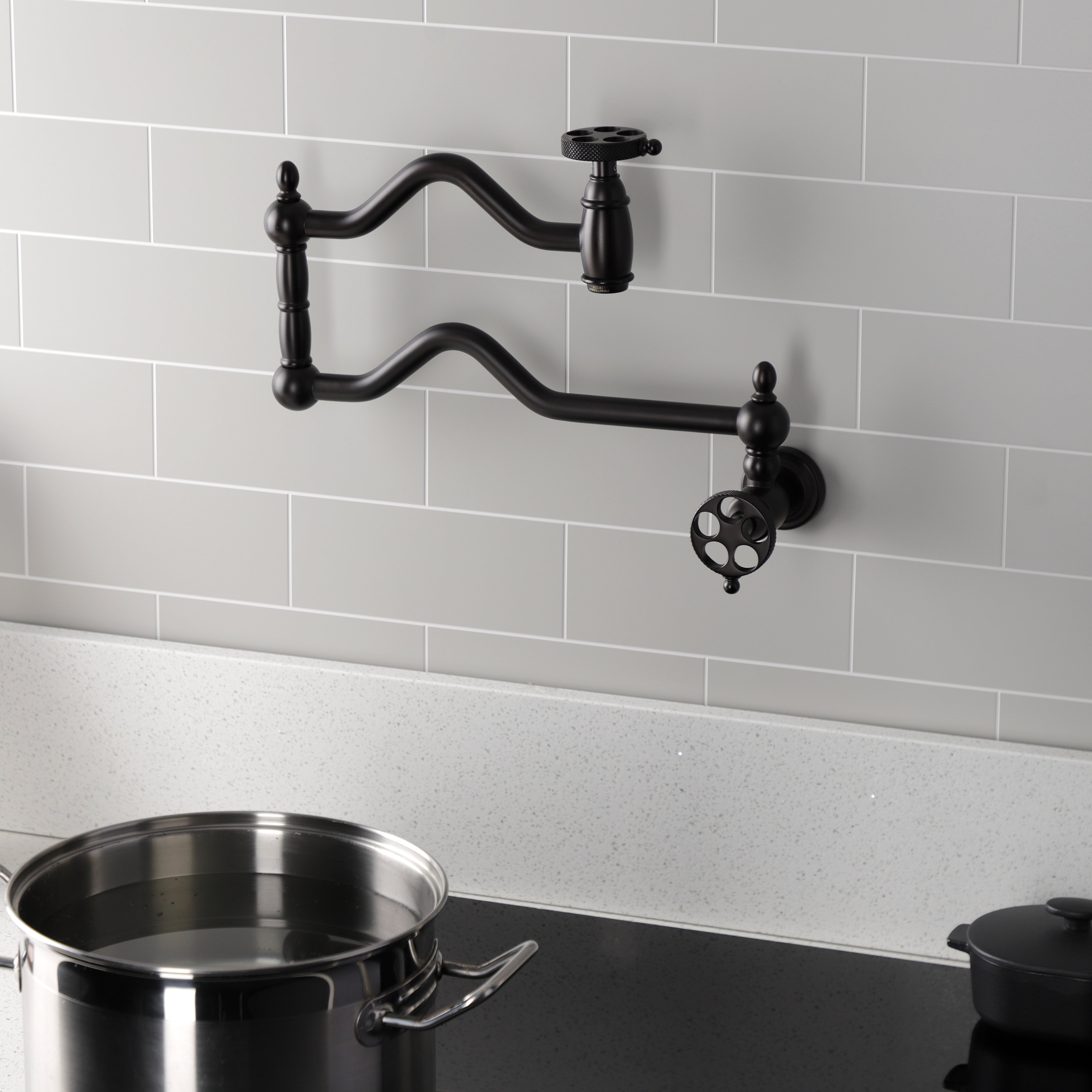 Kingston Brass KS2107RKX Webb Wall Mount Pot Filler Faucet with Knurled Handle, Brushed Brass installed above a pot
