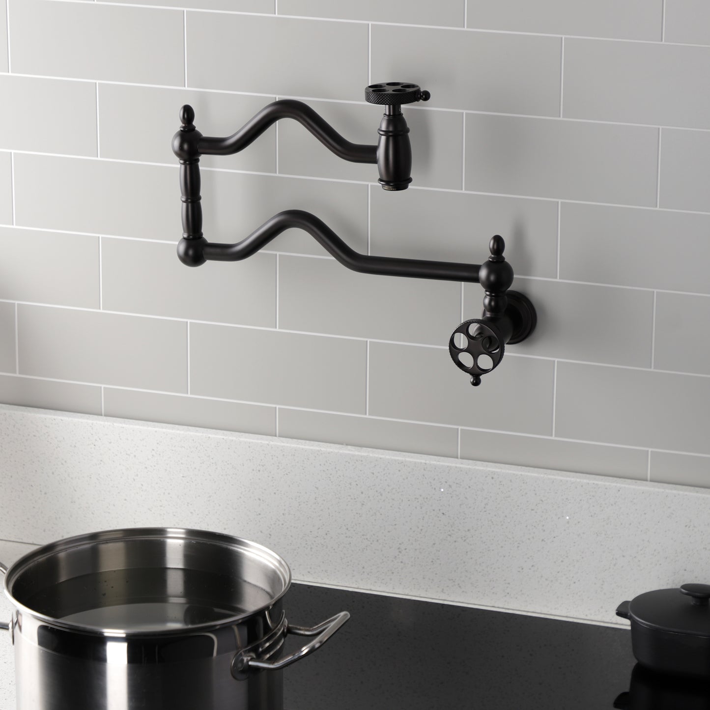 Kingston Brass KS2107RKX Webb Wall Mount Pot Filler Faucet with Knurled Handle, Brushed Brass installed above a pot