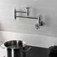 Kingston Brass KS3103RX Belknap Wall Mount Pot Filler Faucet, Antique Brass mounted over a pot on the stove.