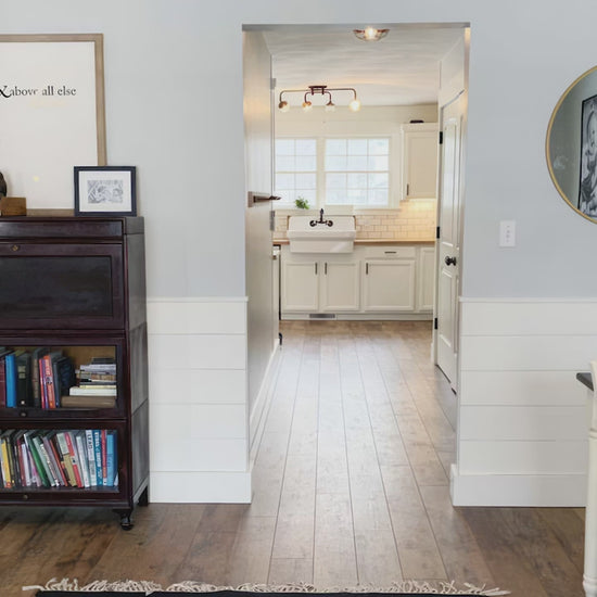 Inviting interior view of a home showcasing a stylish kitchen and a bookshelf.