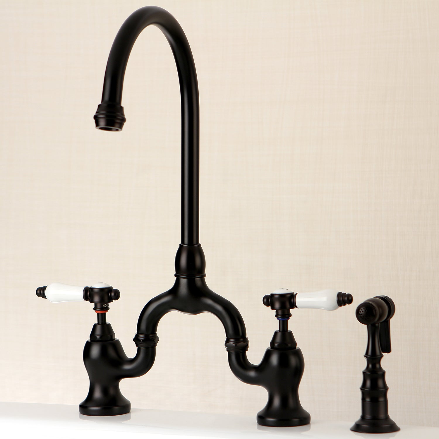 Kingston KS7793BPLBS Bel-Air Bridge Kitchen Faucet with Brass Sprayer, Antique Brass in a sleek black finish.