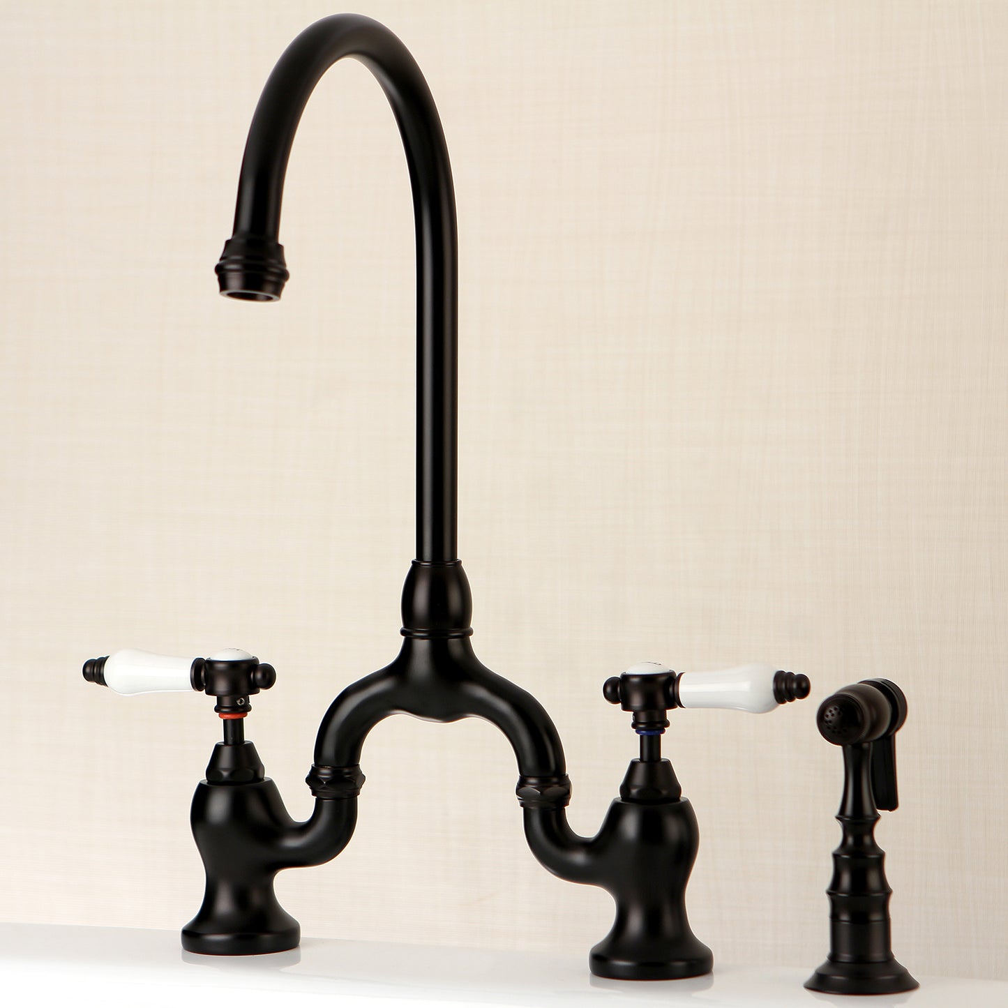 Kingston KS7793BPLBS Bel-Air Bridge Kitchen Faucet with Brass Sprayer, Antique Brass in a sleek black finish.
