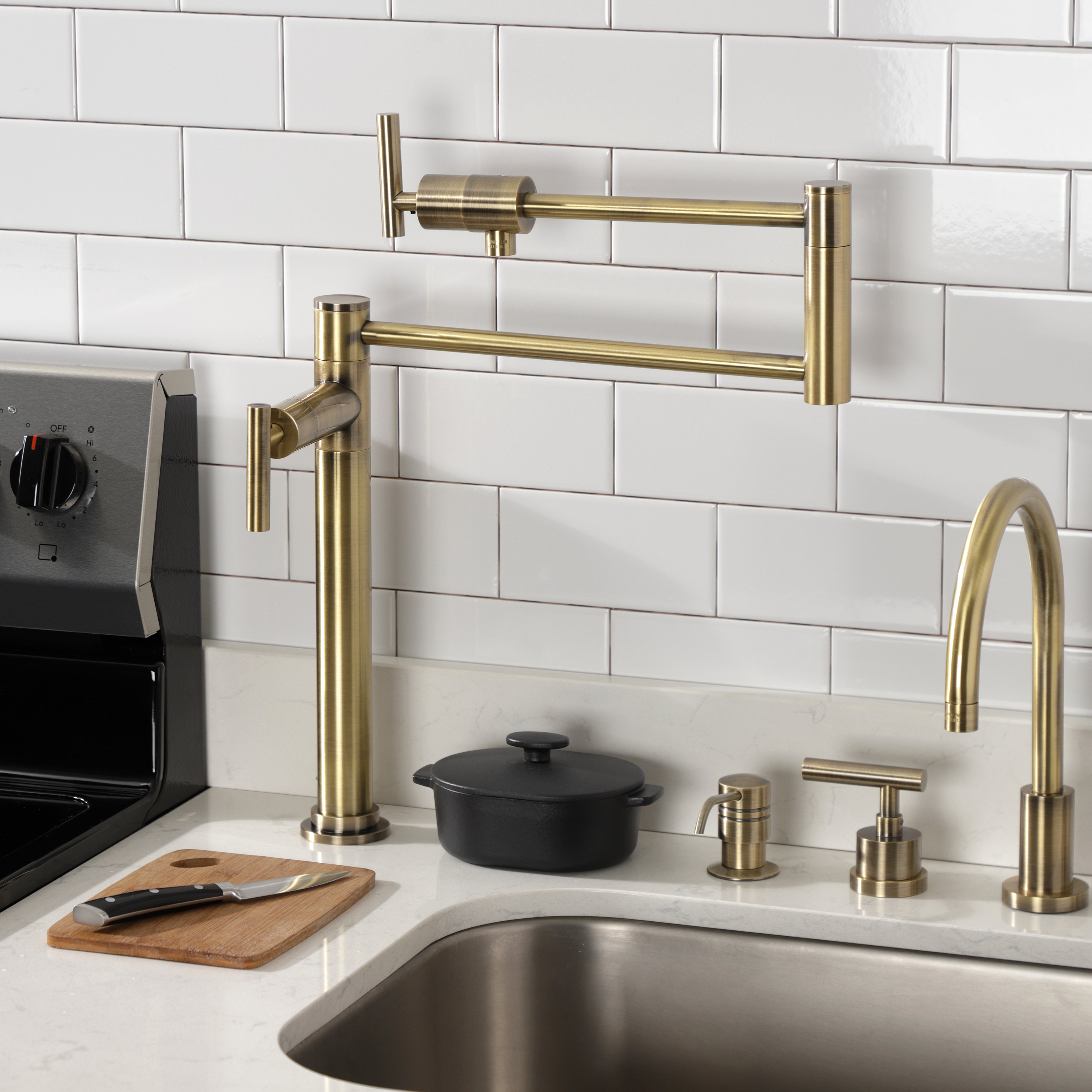 Kingston Brass KS4703CML Manhattan Deck Mount Pot Filler Faucet, Antique Brass installed in a modern kitchen.