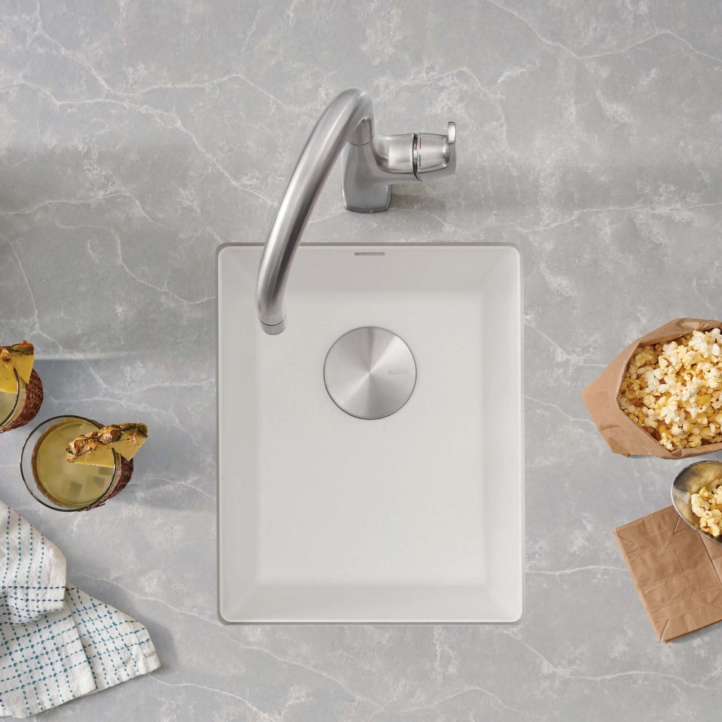 BLANCO Precis SILGRANIT 13" Undermount Bar Sink on a countertop with snacks and drinks around.