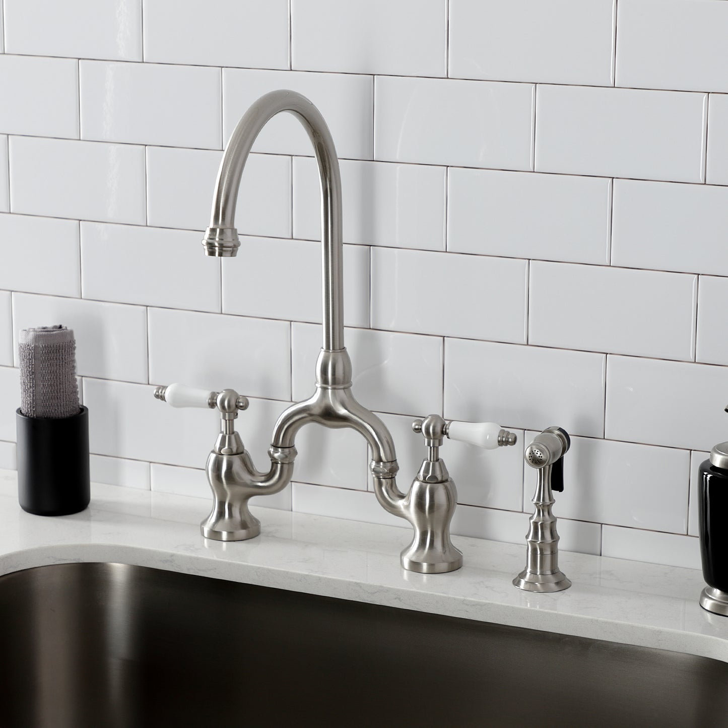 Kingston KS7793PLBS English Country Bridge Kitchen Faucet with Brass Sprayer, Antique Brass in a modern kitchen setting.