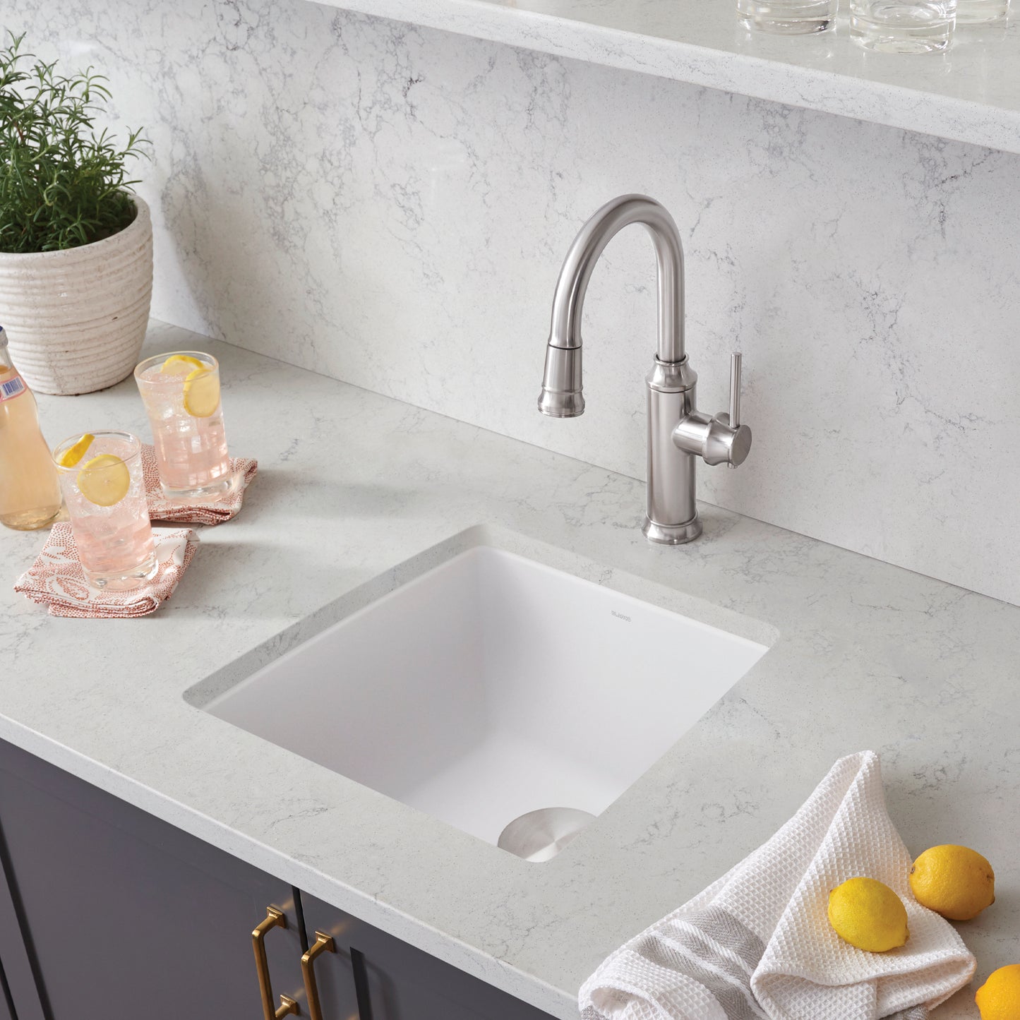 BLANCO Performa SILGRANIT 17" Undermount Bar Sink with modern faucet and lemon garnished drinks on countertop.