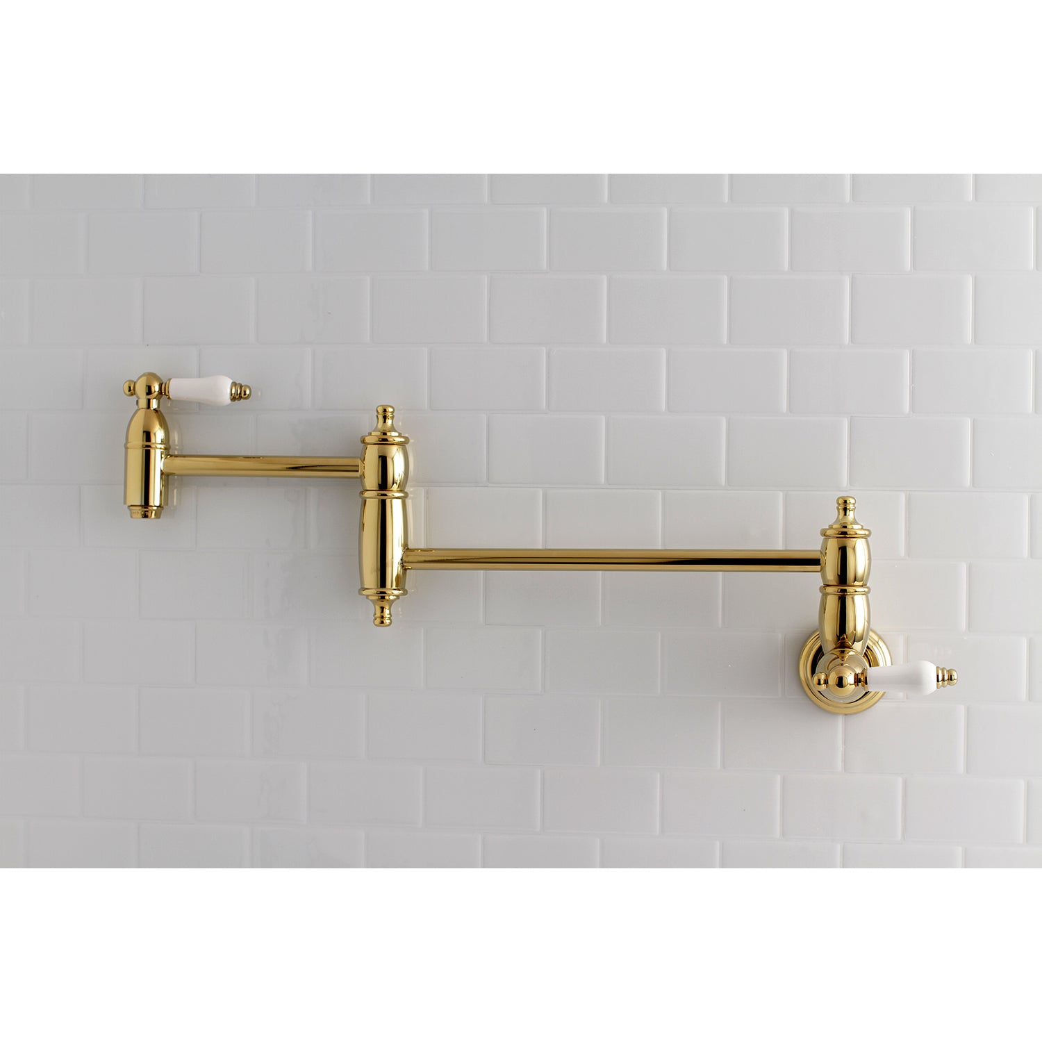 Kingston Brass KS3103PL Restoration Wall Mount Pot Filler Faucet, Antique Brass on a white tiled wall.