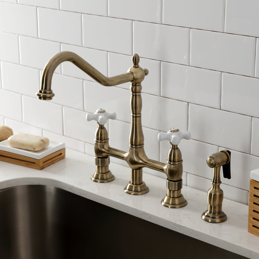 Kingston Brass Heritage Bridge Kitchen Faucet with Brass Sprayer and Cross Handles in antique brass finish