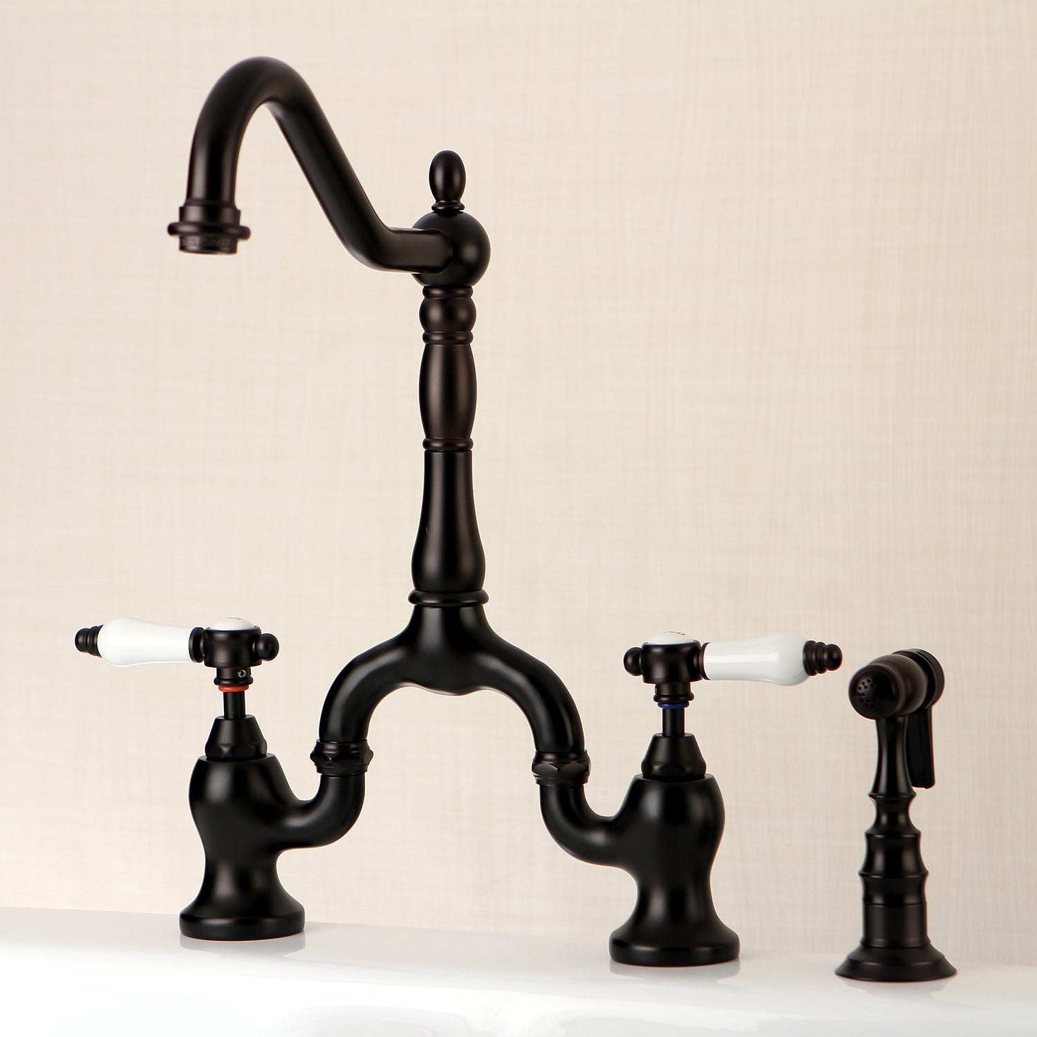 Kingston KS7753BPLBS Bel-Air Bridge Kitchen Faucet with Brass Sprayer, Antique Brass design with elegant black finish and white porcelain levers