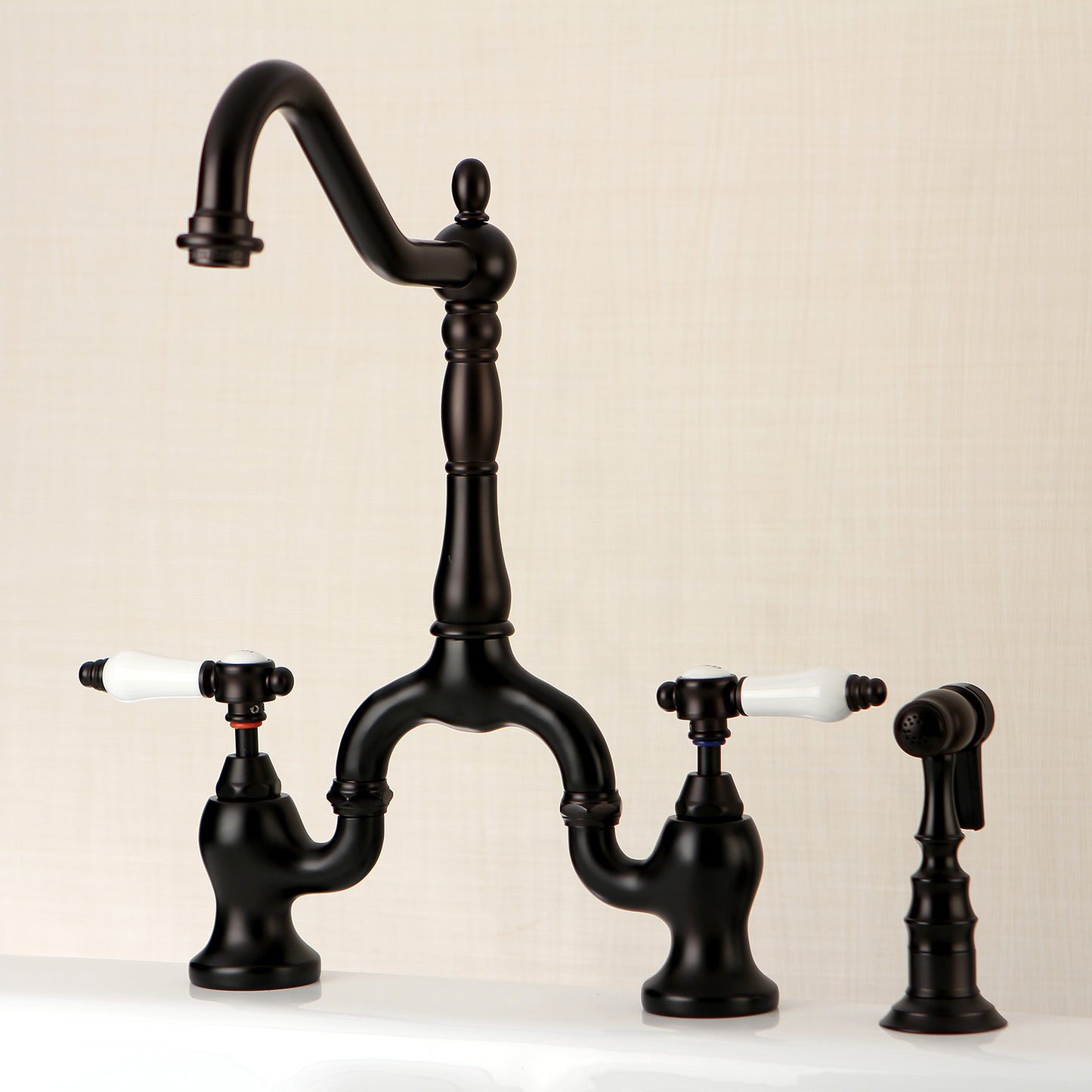 Kingston KS7753BPLBS Bel-Air Bridge Kitchen Faucet with Brass Sprayer, Antique Brass design with elegant black finish and white porcelain levers
