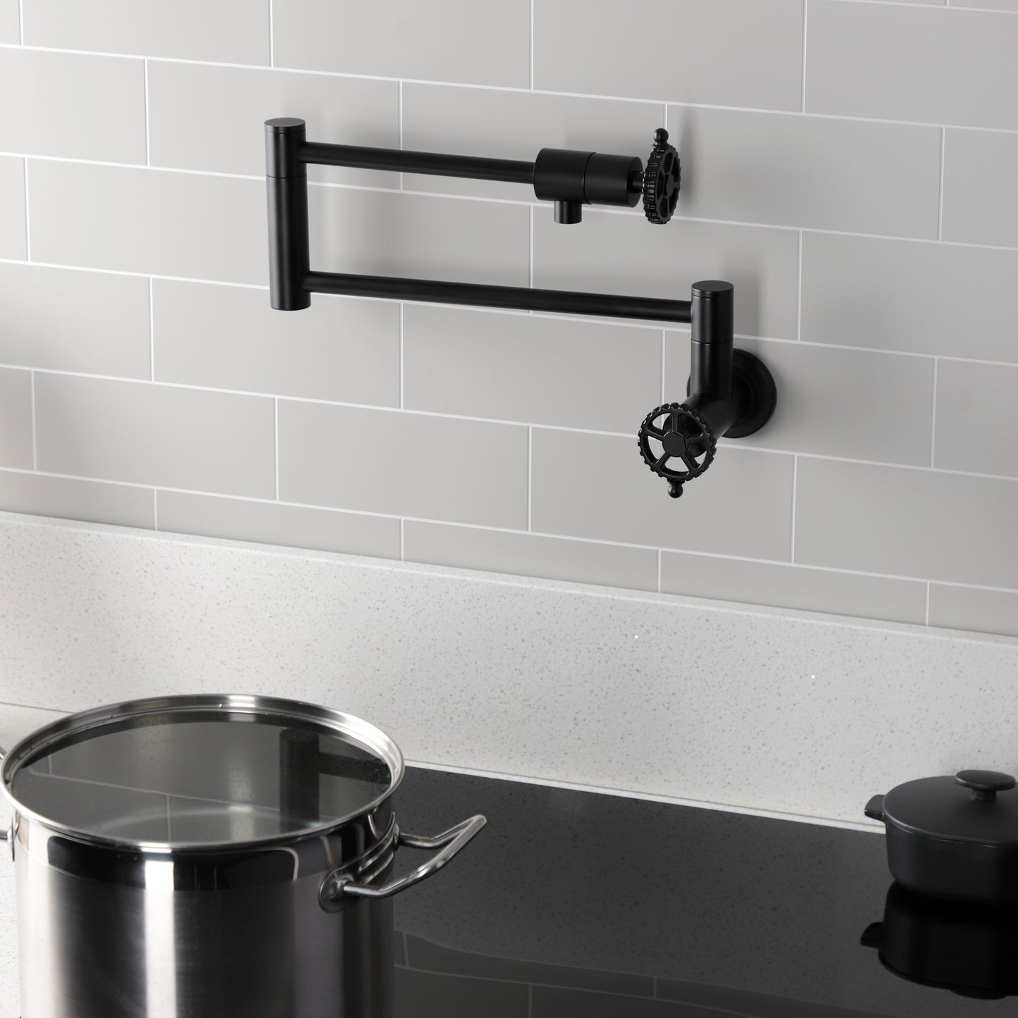 Kingston Brass KS4103CG Fuller Wall Mount Pot Filler Faucet, Antique Brass in a modern kitchen setting with cookware.