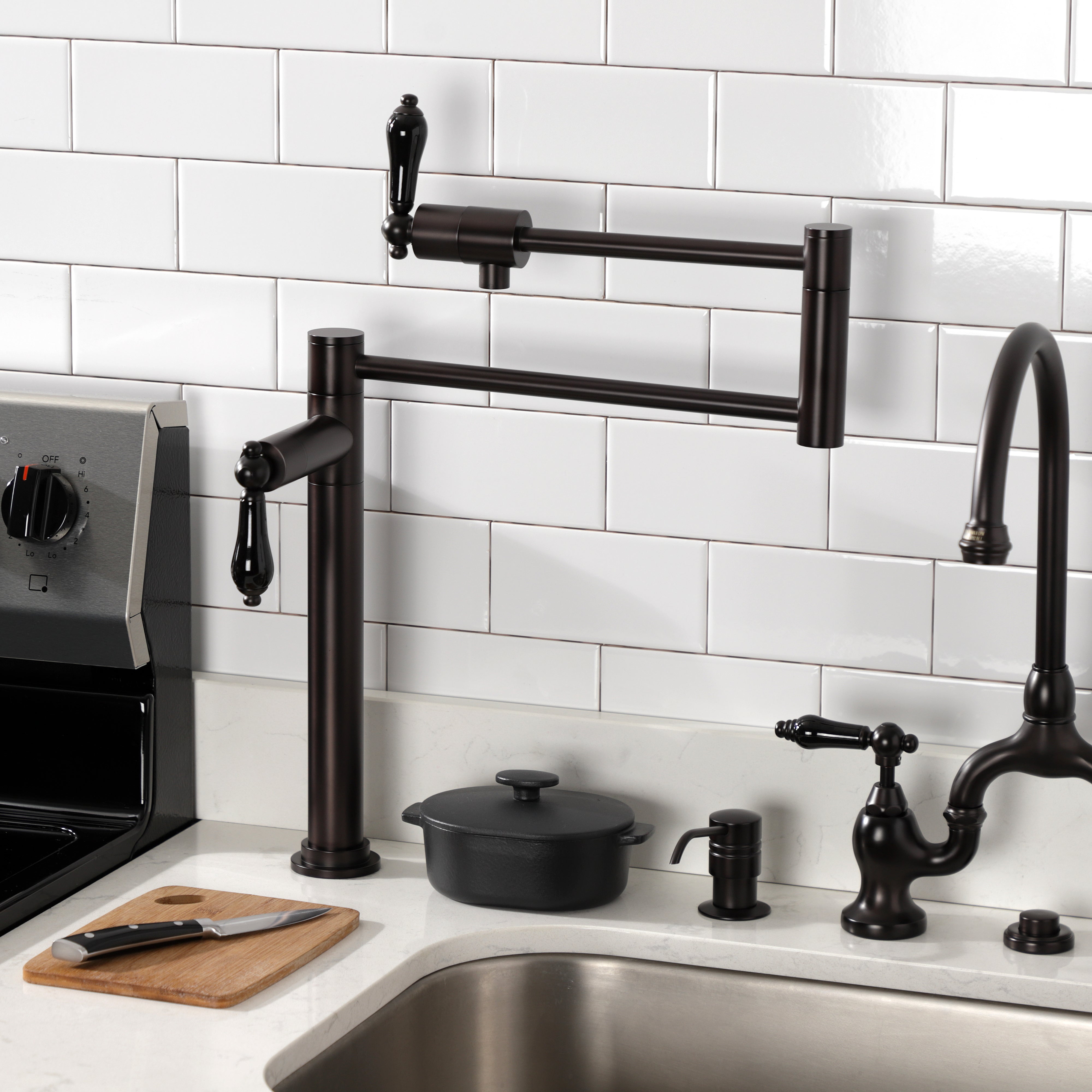 Kingston Brass KS4707PKL Duchess Deck Mount Pot Filler Faucet, Brushed Brass in a stylish kitchen setting with black porcelain handles.