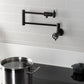 Kingston Brass KS4103CG Fuller Wall Mount Pot Filler Faucet, Antique Brass on kitchen wall with pot.