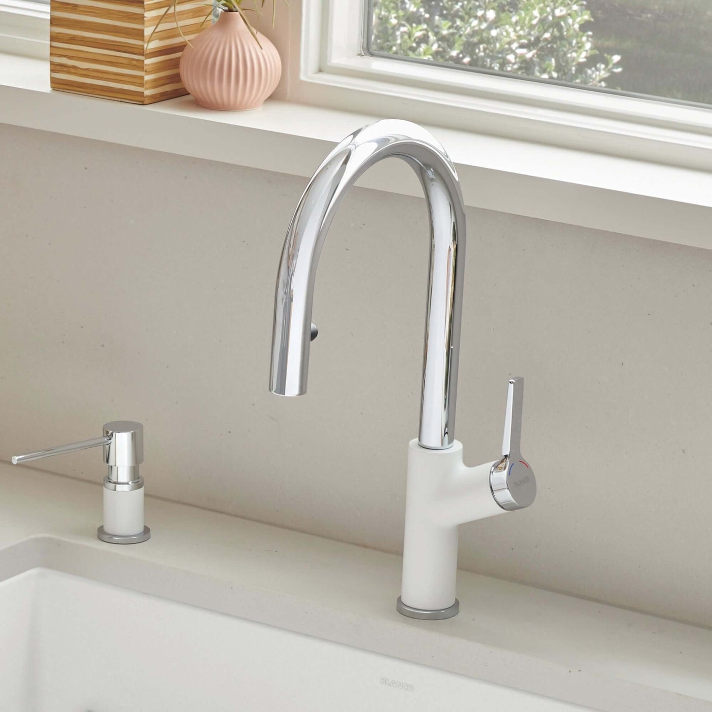 BLANCO Urbena Pull-Down Dual-Spray Kitchen Faucet with a sleek chrome and white design by the sink.