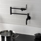 Kingston Brass KS4103KL Whitaker Wall Mount Pot Filler Faucet, Antique Brass in a modern kitchen setting.