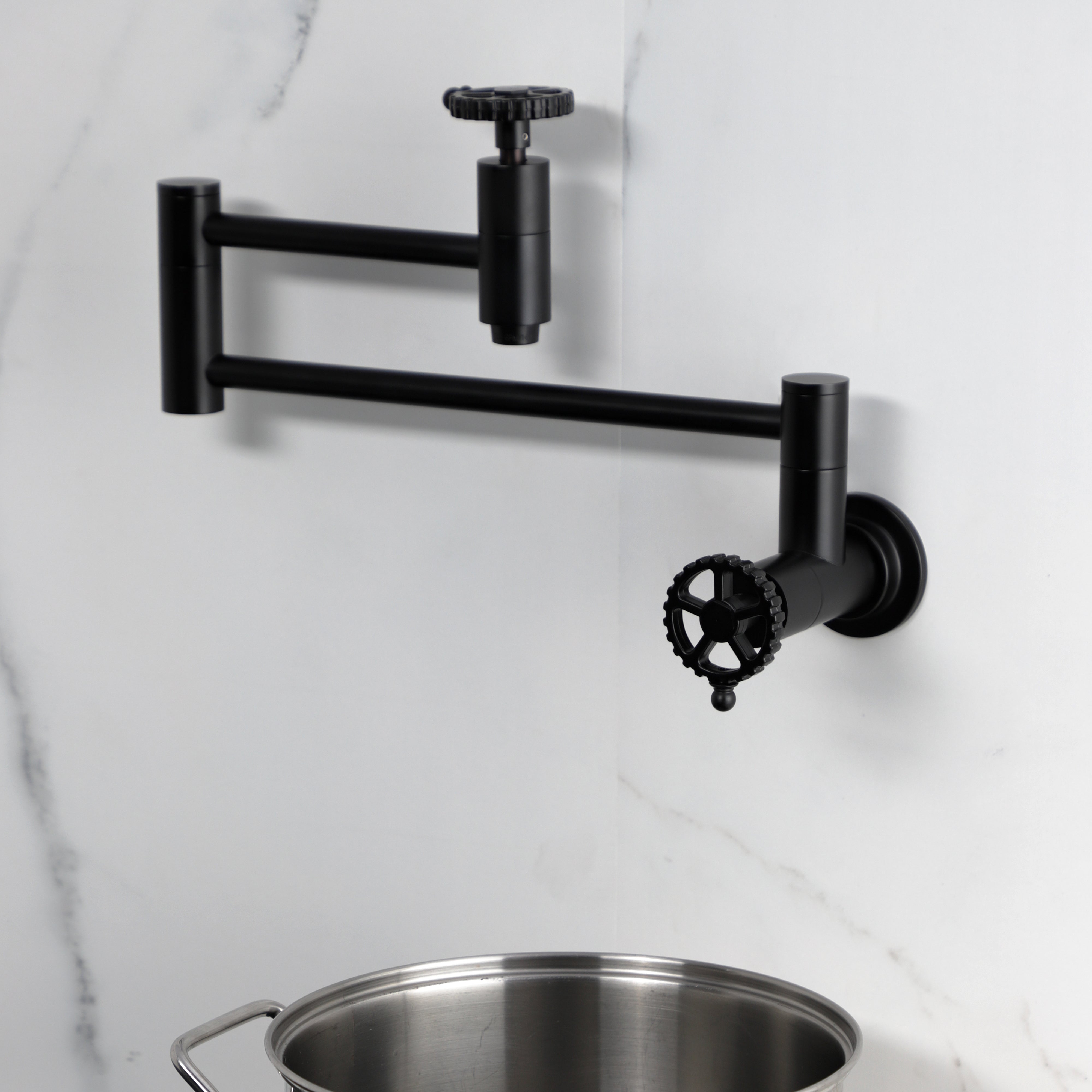 Kingston Brass KS8103CG Fuller Wall Mount Pot Filler Faucet, Antique Brass mounted, displayed with a pot
