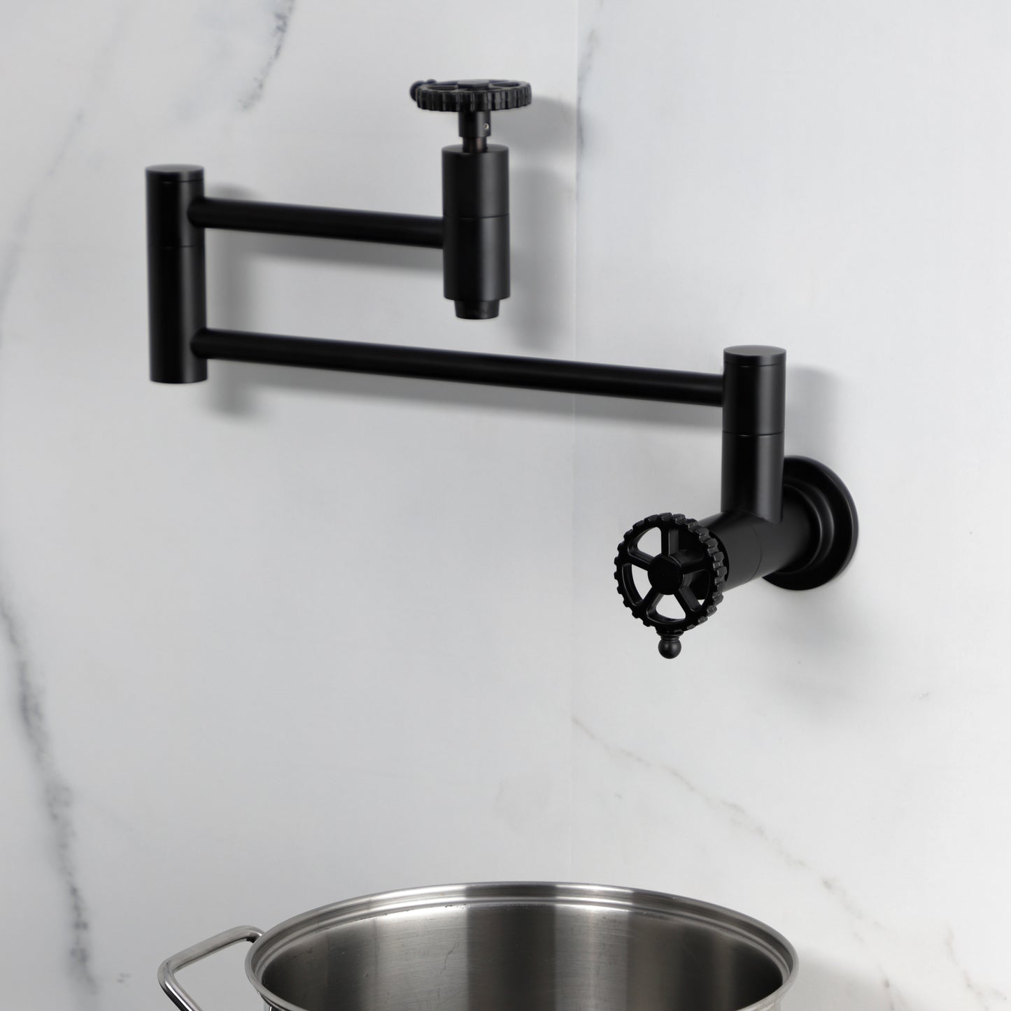 Kingston Brass KS8103CG Fuller Wall Mount Pot Filler Faucet, Antique Brass mounted, displayed with a pot