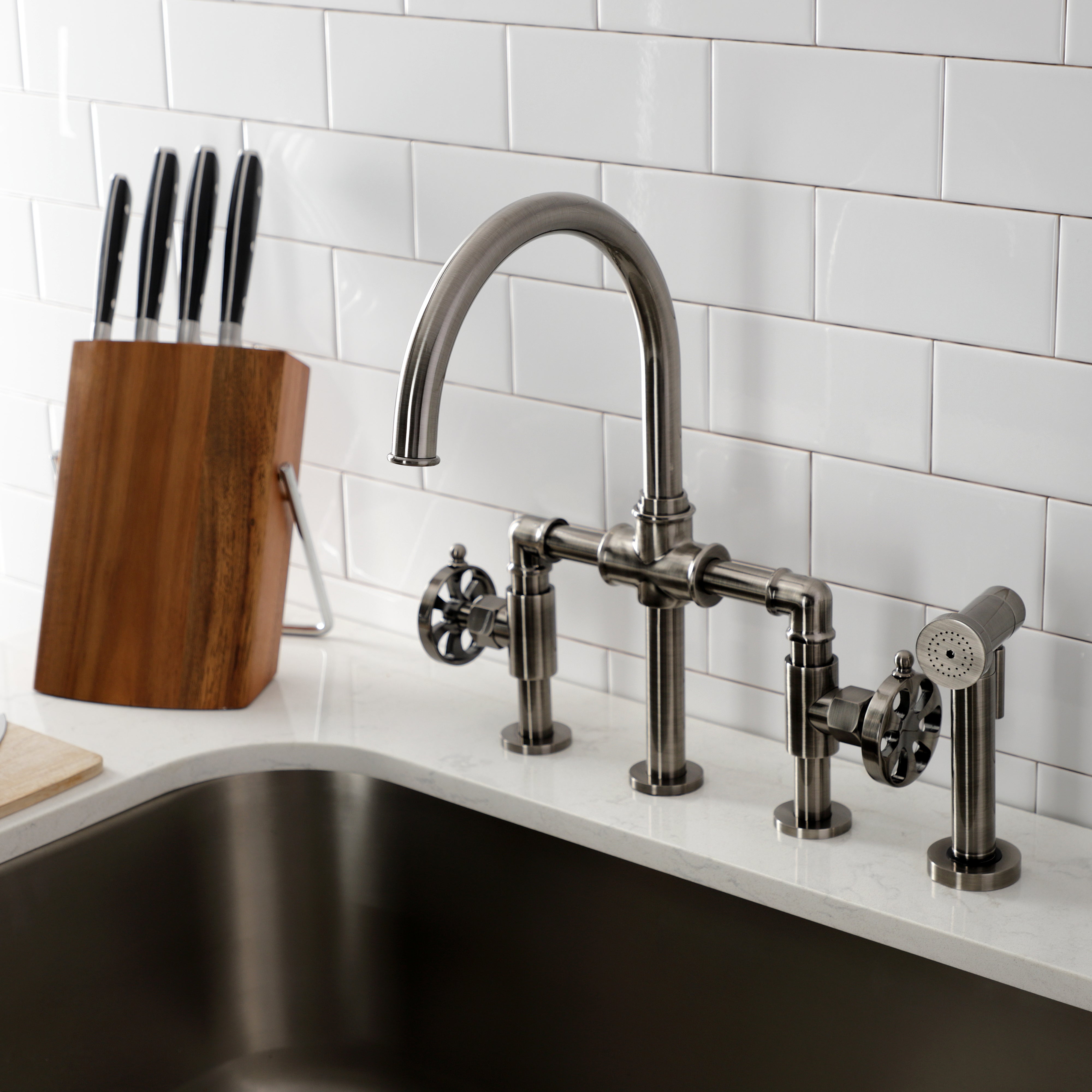 Kingston KS2333RX Belknap Industrial Style Bridge Kitchen Faucet with Brass Sprayer, Antique Brass in modern kitchen setting